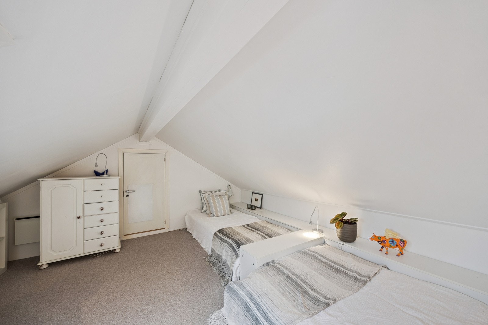 Soverom med parkett og skråtak, noe som gir rommene en lun og hyggelig karakter Galleribilde