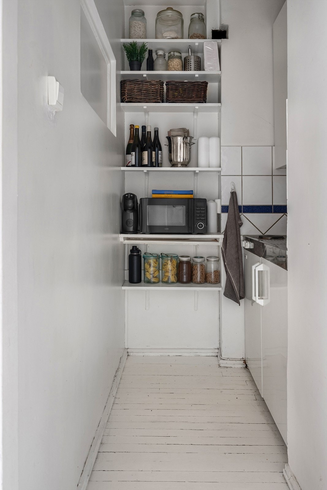 Plassbesparende kjøkkenløsning med god oppbevaringsplass i åpen nisje Galleribilde