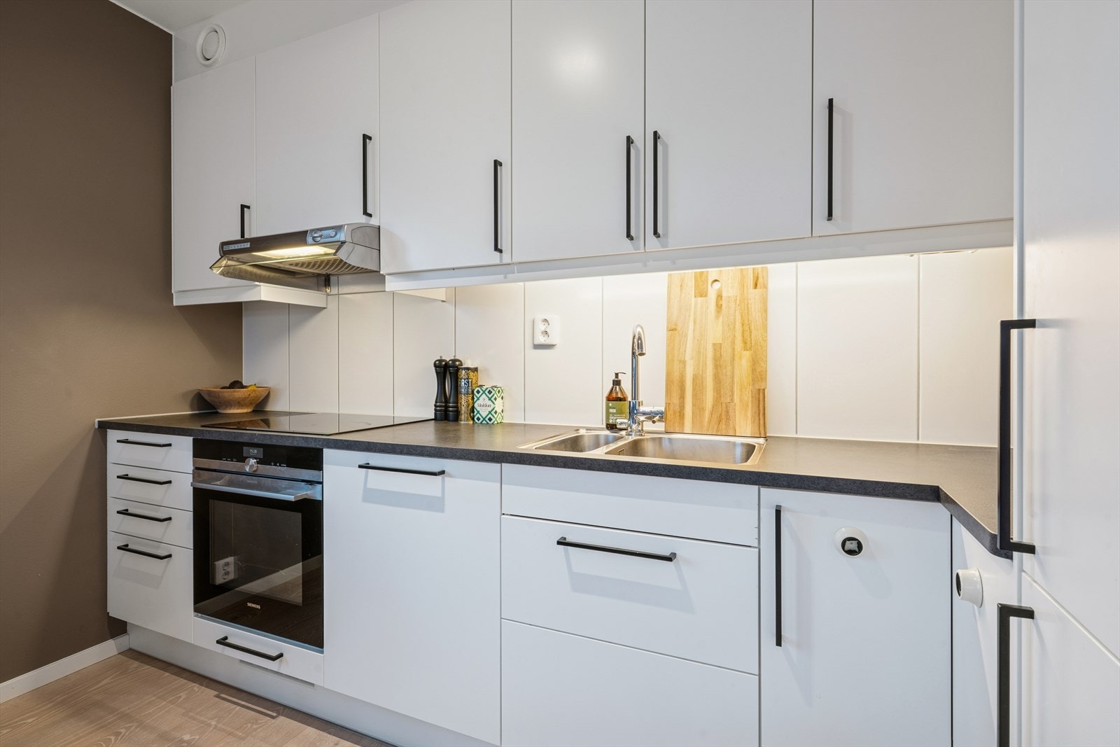 Kjøkkenet er utstyrt med integrerte hvitevarer som induksjonstopp, stekeovn, oppvaskmaskin samt kjøle-/fryseskap. Galleribilde