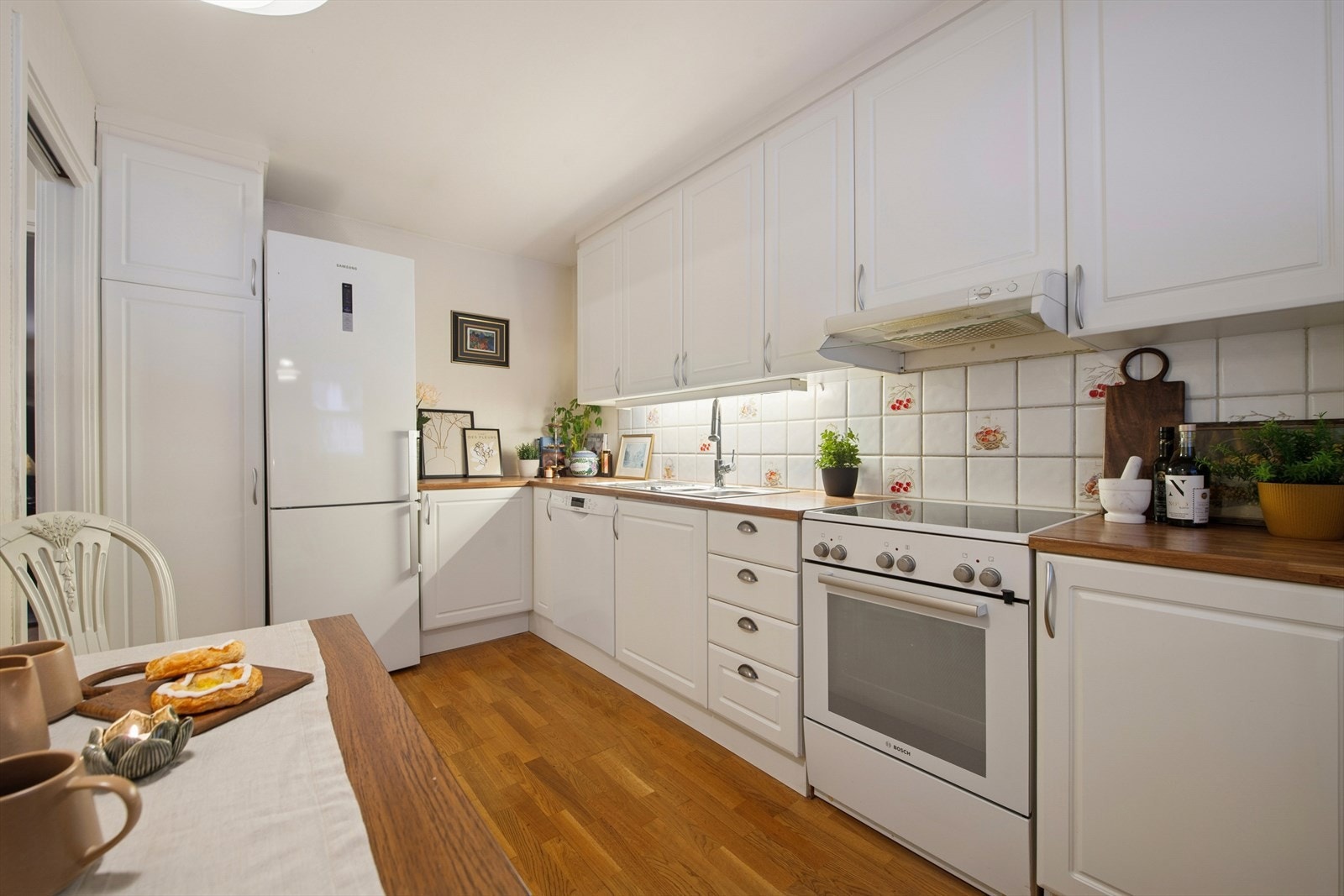 Kjøkkenet består av en lys innredning med glatte foilerte fronter og benkeplater i tre. Galleribilde