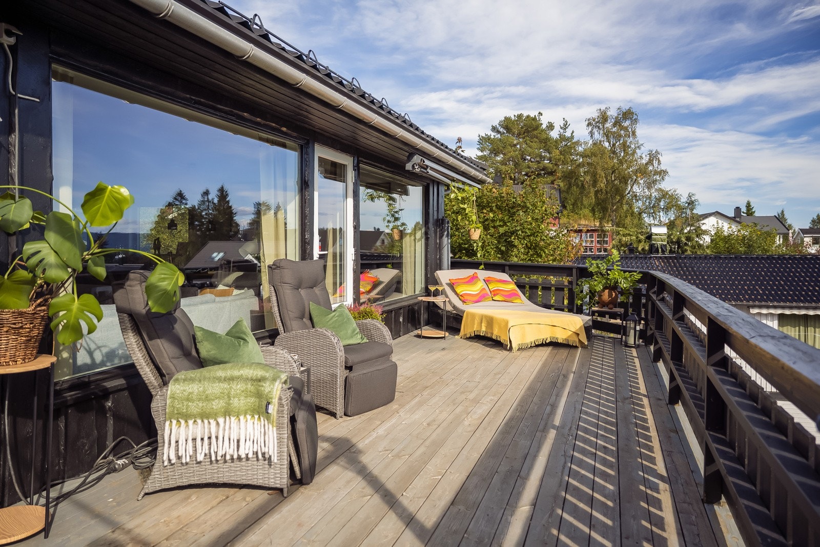 Terrassen strekker seg fra utenfor stueviundet, rundt huset mot inngangspartiet. Galleribilde