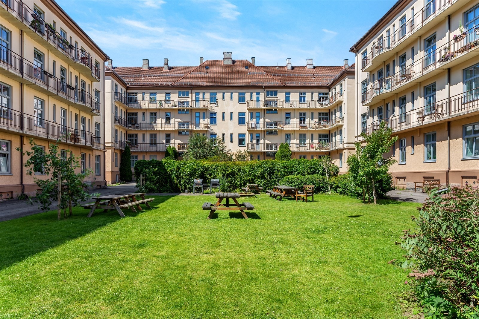 Idyllisk bakgård med flere sittegrupper, grill og flotte grøntarealer Galleribilde