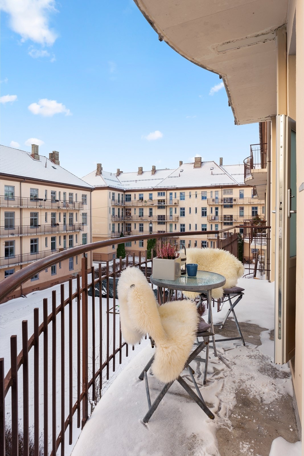 Brannbalkongen vender mot en rolig og pent opparbeidet bakgård Galleribilde