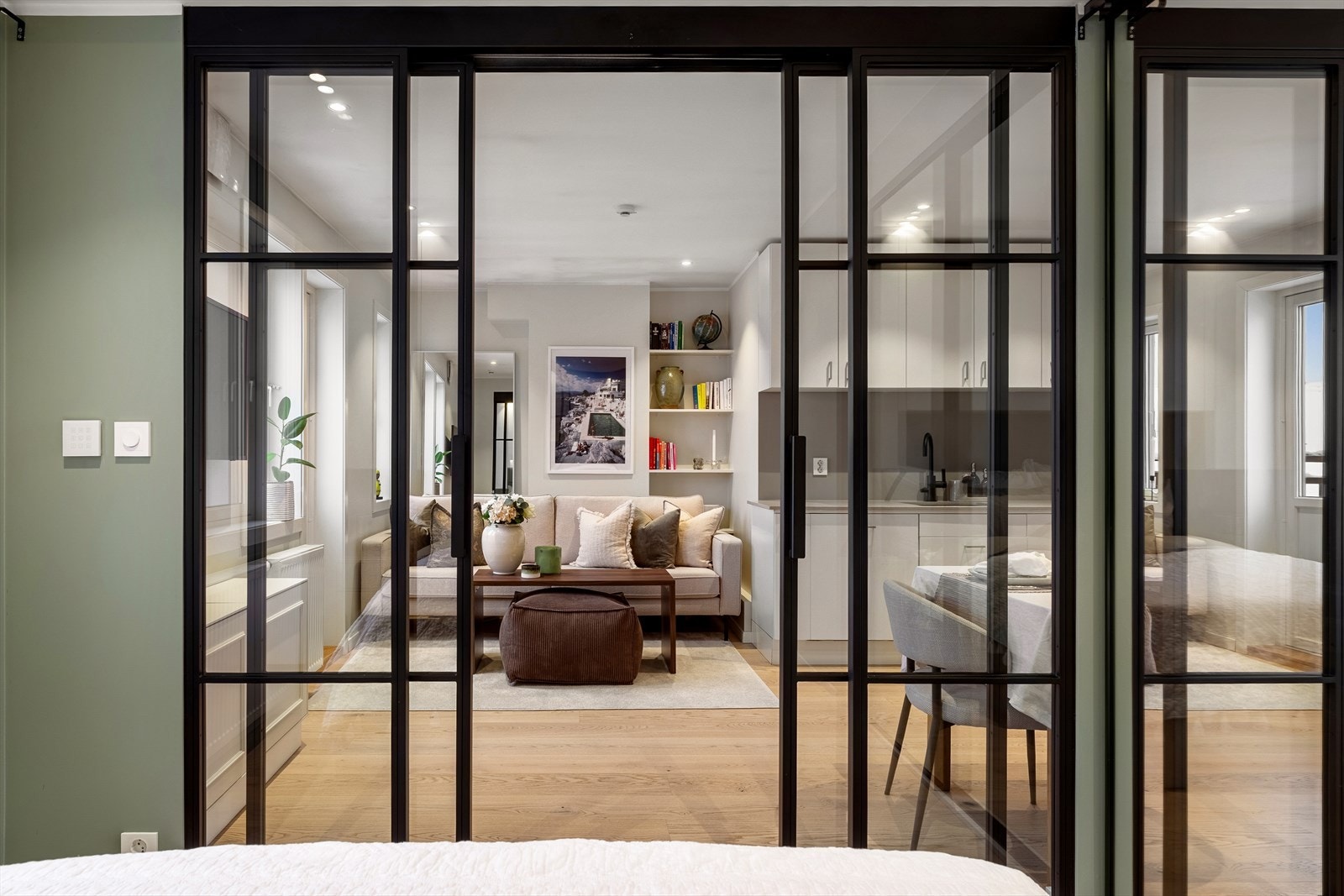 Det er lagt flid i materialvalget i denne leiligheten - flott skyvedør av smijern og glass skiller soverommet fra stuen. Galleribilde