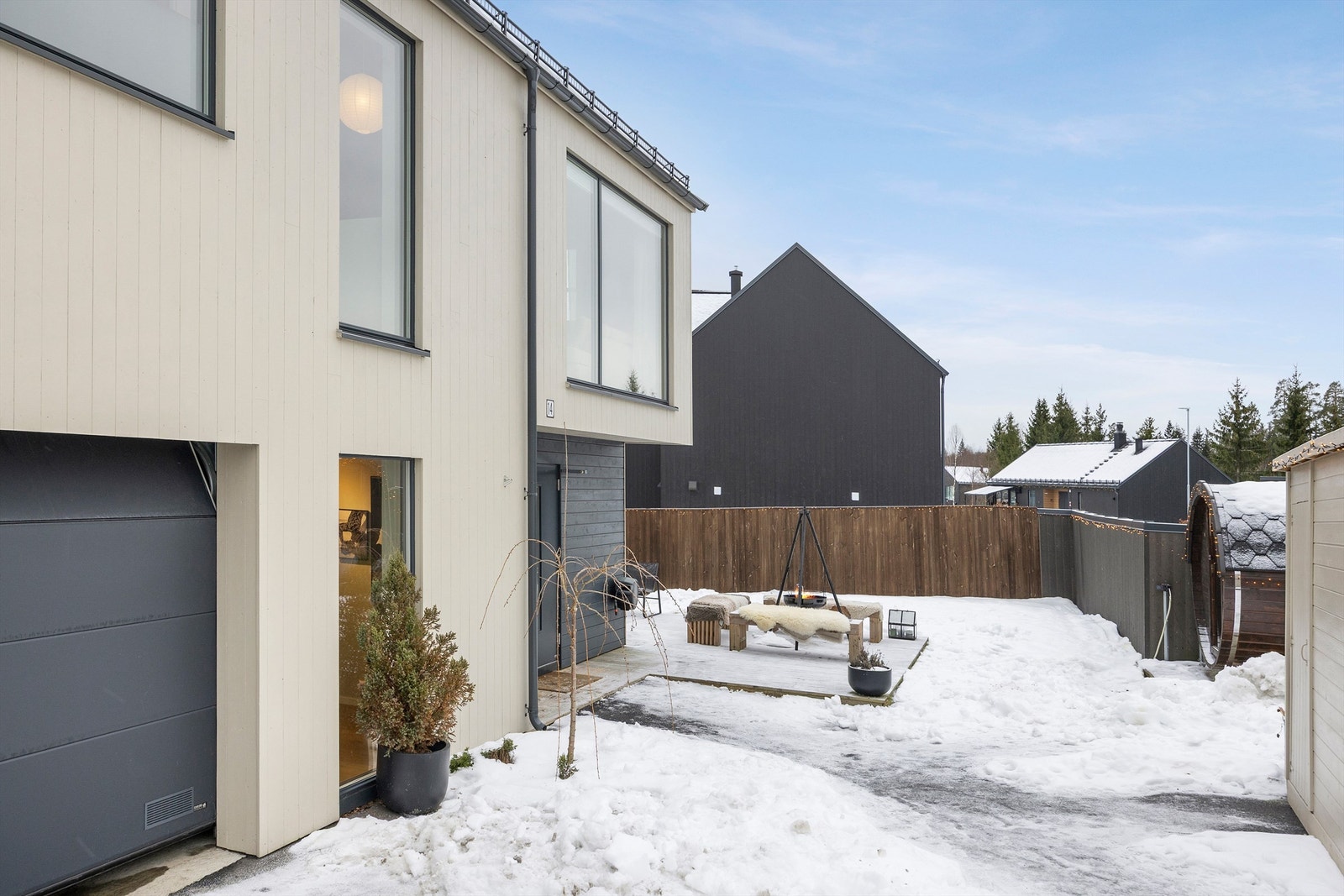 Pent opparbeidet tomt med markterrasser, gressplen, badstue og vedbod. Galleribilde