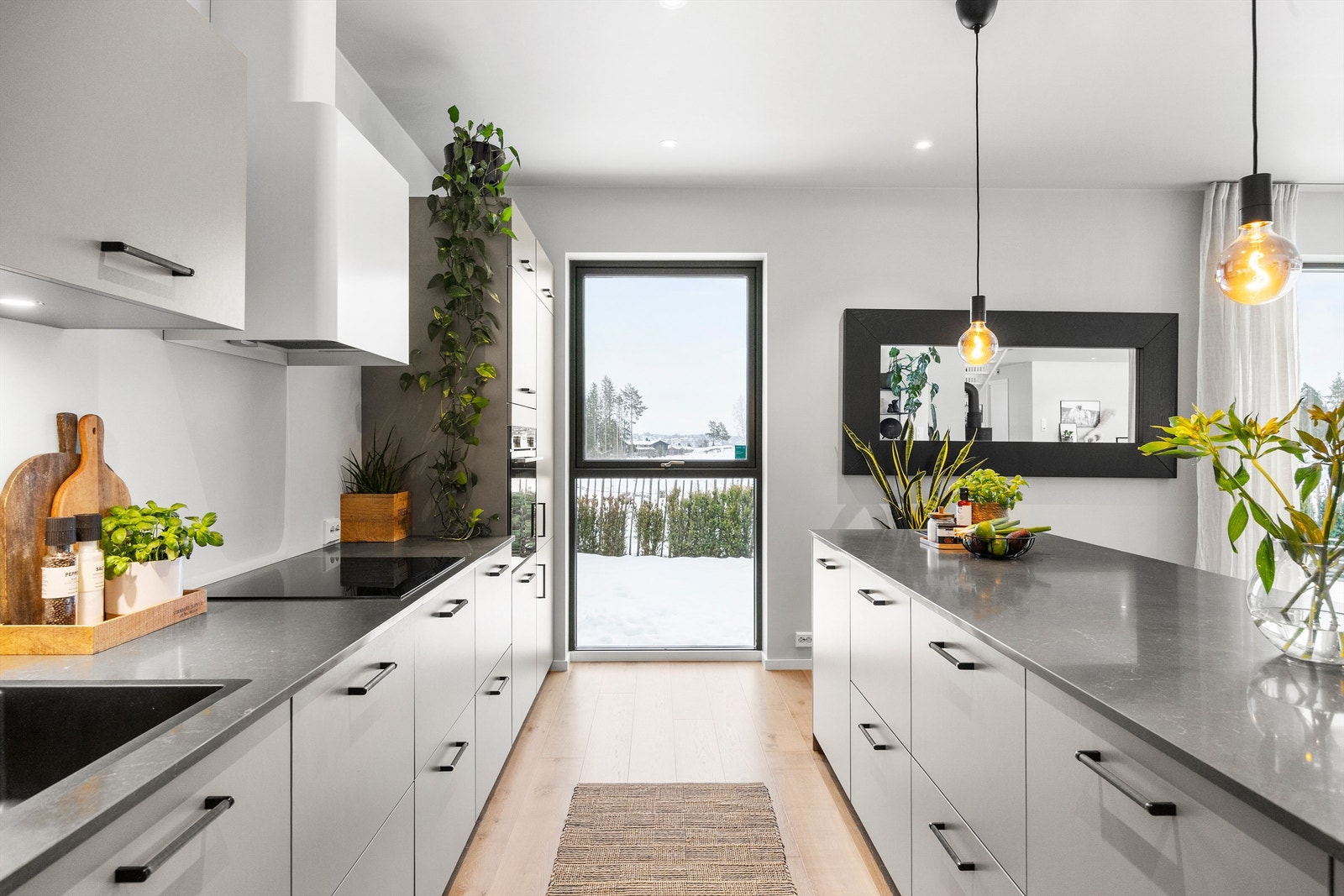 Innredning med slette fronter og benkeplate i polert stein. Galleribilde