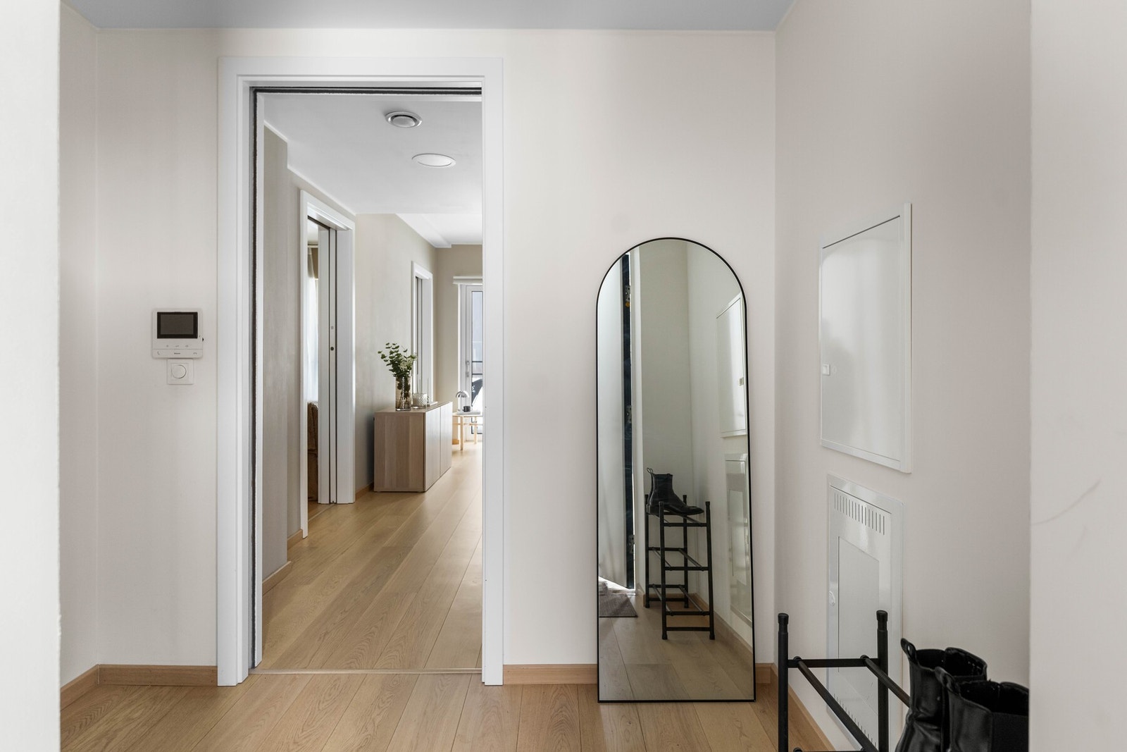Lys og tiltalende entrè med lyspigmentert parkett på gulv, som gir et godt førsteinntrykk av leiligheten. Himlingen er pent lyssatt med downlights, og det er montert dørcalling ved inngangsdøren. Galleribilde