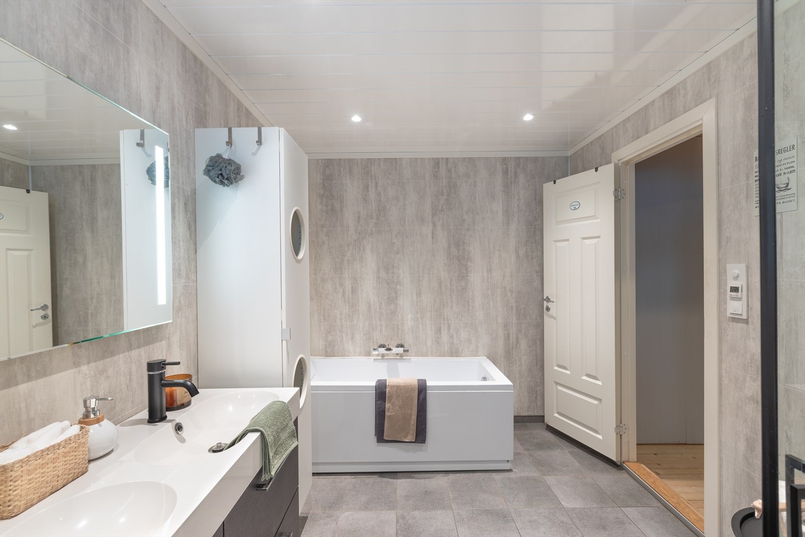 Rommet har badekar og praktisk innredning med to nedfelte servanter. Galleribilde