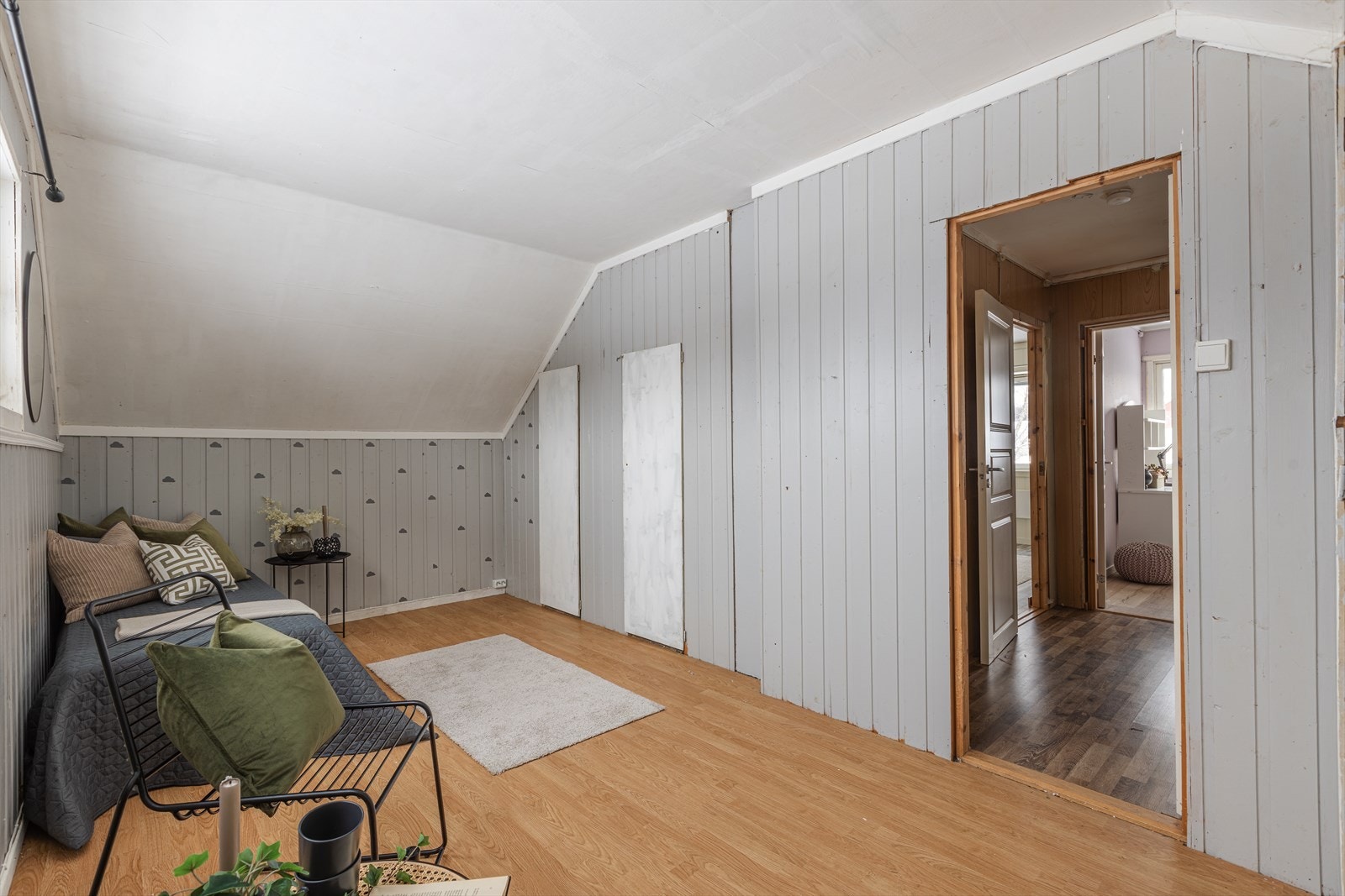 Rommet har panelvegger og laminatgulv, med tilgang til tilstøtende rom. Galleribilde