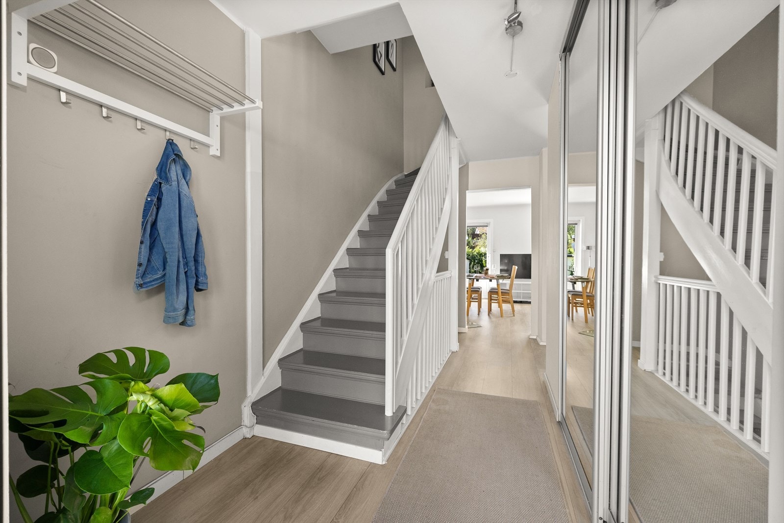 Velkommen inn! Leiligheten ønsker deg velkommen med en lys og innbydende entré som gir et umiddelbart godt førsteinntrykk. Her er det god plass til oppbevaring av yttertøy og sko i en romslig skyvedørsgarderobe med stilrene speilfronter. Galleribilde