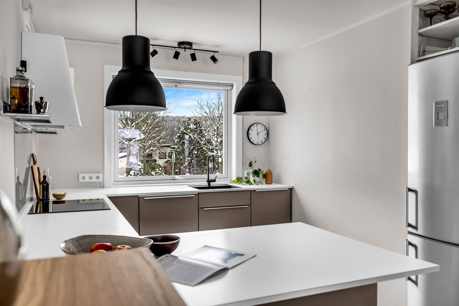 Kjøkkenet har en praktisk kjøkkenbenk med spiseplass vendt mot stuen. Galleribilde