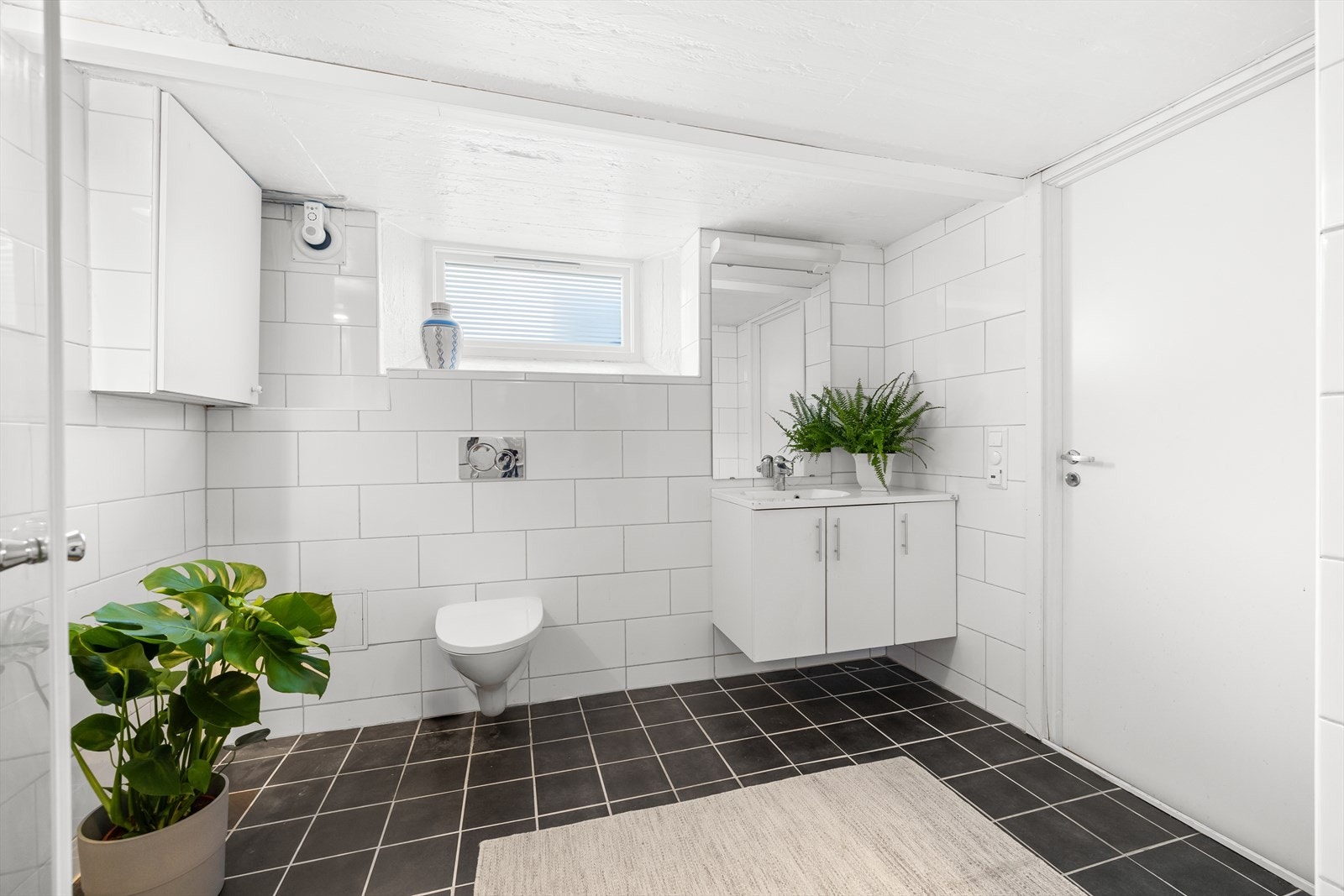 Dusjhjørne rett på gulv med innfellbare glassdører, dusjbatteri og hånddusj. Det er opplegg og plass til både vaskemaskin og tørketrommel. Sikringsskapet er plassert i plassbygd skap. Høiax varmtvannsbereder på 287 liter fra 2011. Galleribilde