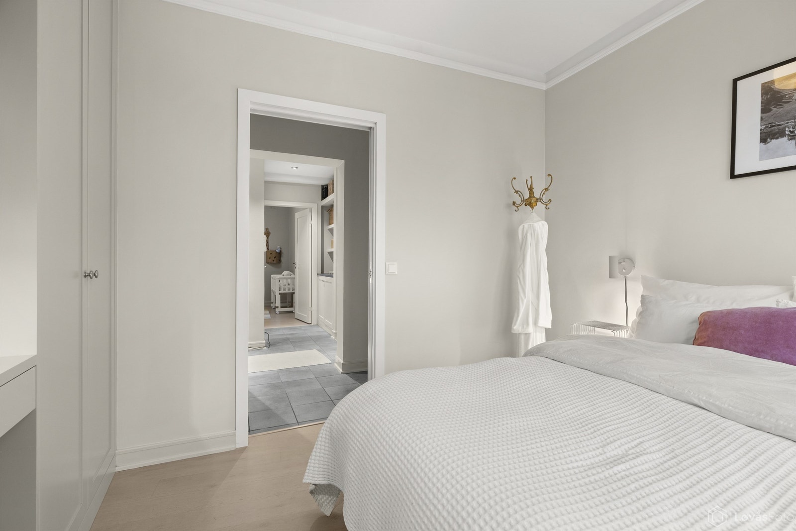 Fra hovedsoverommet går man inn i en flislagt mellomgang med flere lekre, plassbygde løsninger for smart oppbevaring. Galleribilde