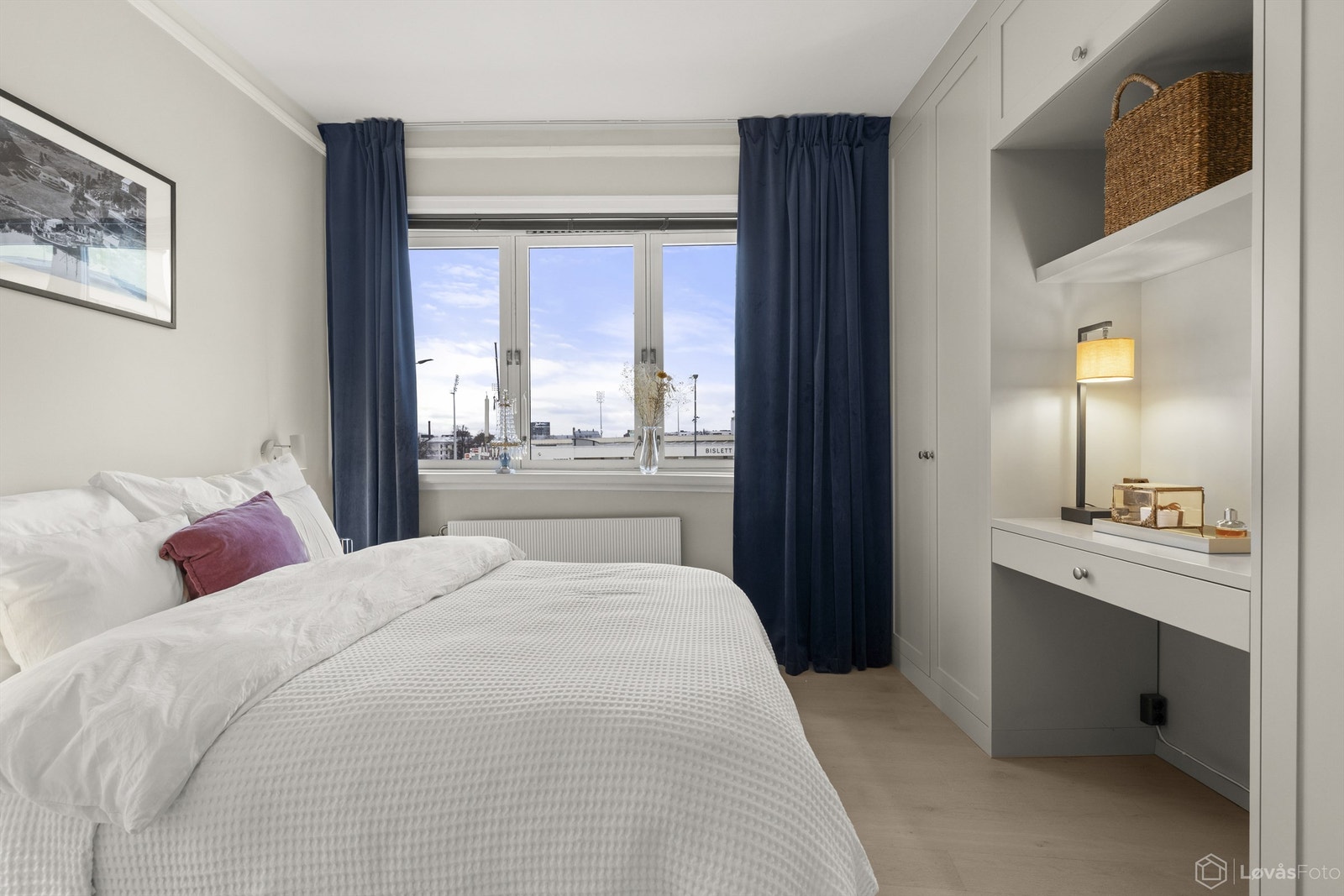 Romslig hovedsoverom med plassbygget garderobeløsning som inkluderer en praktisk arbeidsplass. Galleribilde