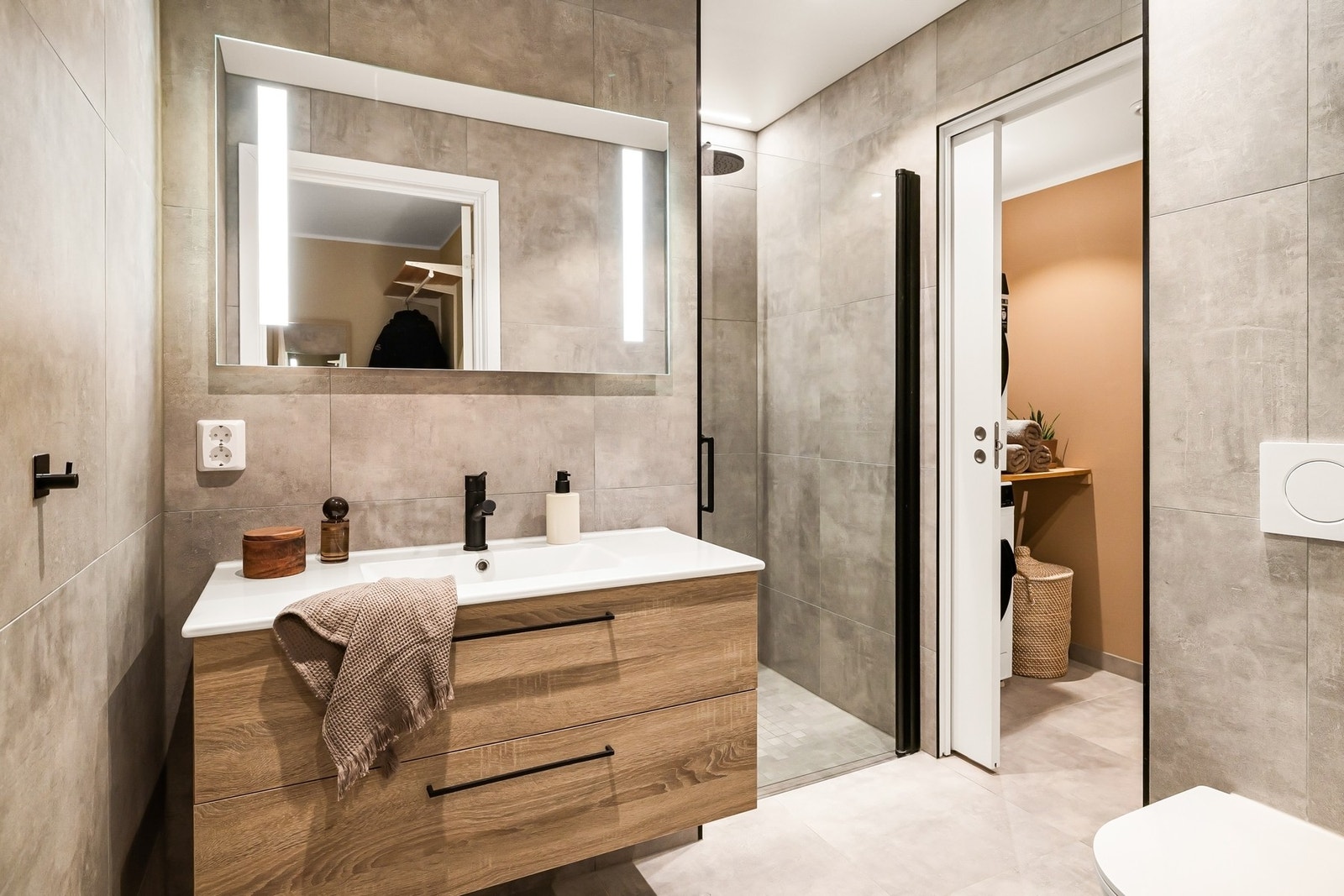 Rommet inneholder innredning med servant, dusjnisje med dobbeldusj, toalett, speil og belysning Galleribilde