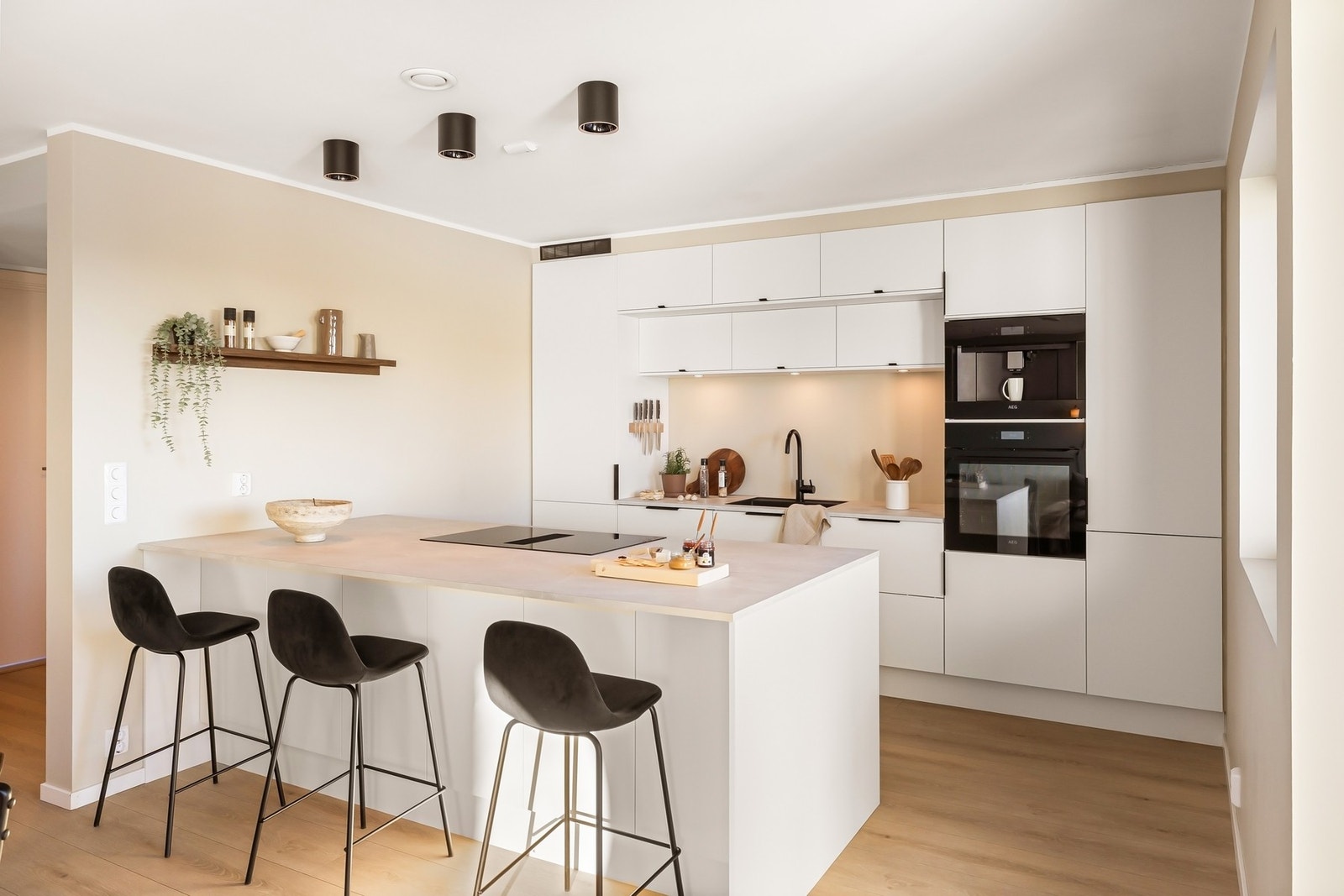 Lekkert kjøkken med sosial øy, god med skap- og benkeplass og integrerte hvitevarer Galleribilde