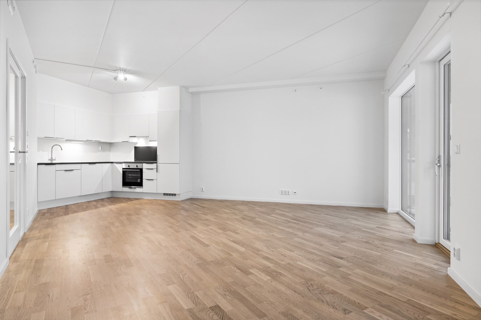 Her bor du i en lys hjørneleilighet med en sosial, åpen stue- og kjøkkenløsning, 2 soverom, pent flislagt baderom og separat tolettrom. Galleribilde