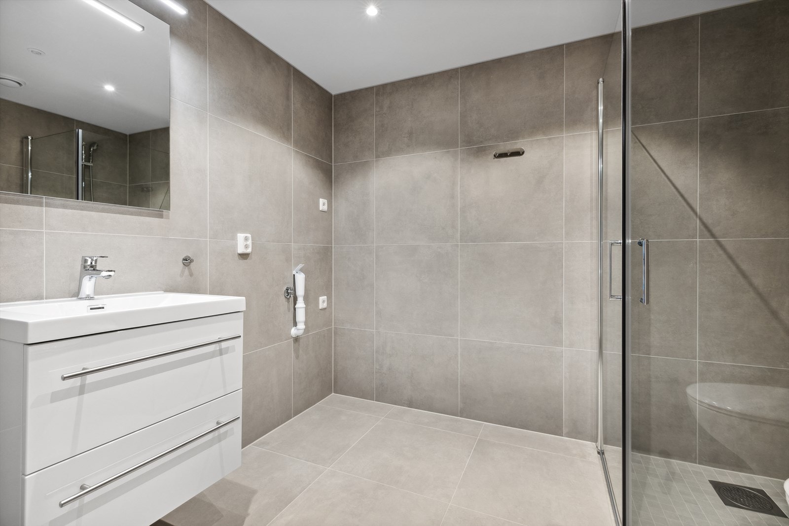 Badet har elektriske varmekabler i gulvet og opplegg for vaskemaskin. Galleribilde