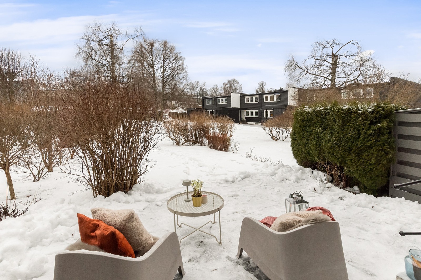 Terrassen går over i hageområde, opparbeidet med hekk og busker Galleribilde