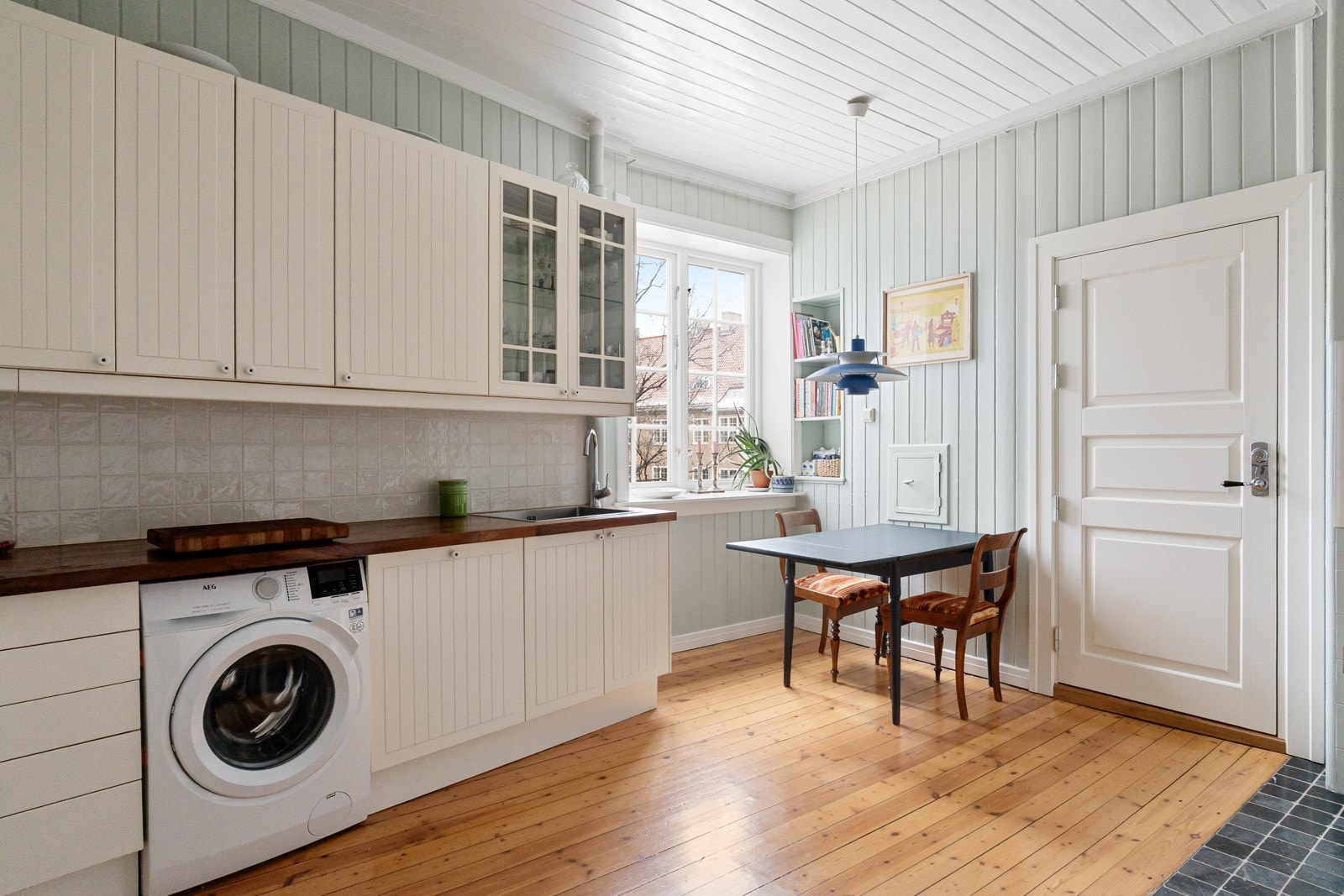 Det er heltre benkeplate med nedfelt kum i rustfritt stål, og fliser på vegg over benkeplaten gir en praktisk og funksjonell arbeidsflate. Galleribilde