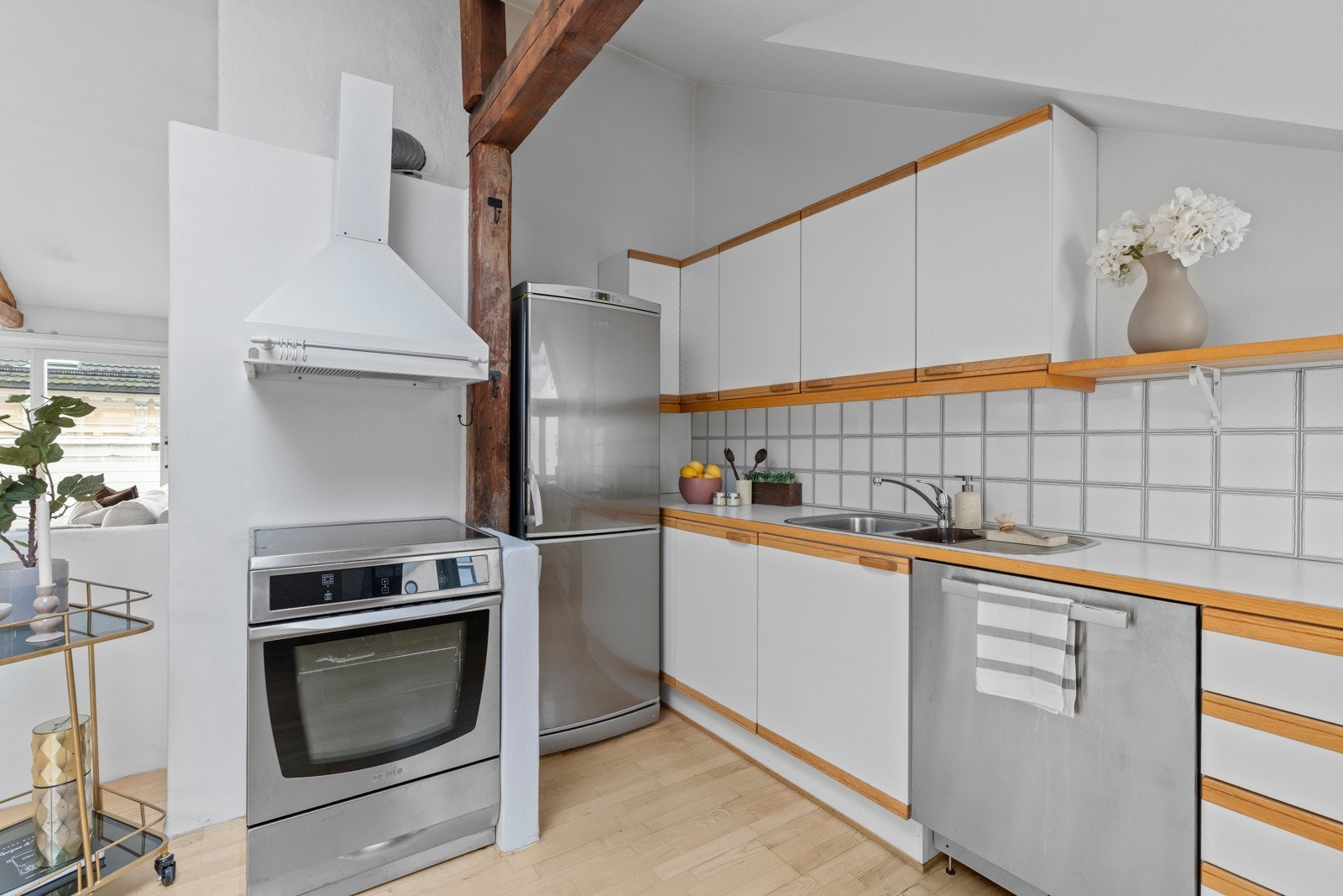 Laminat benkeplate med nedfelt dobbelt oppvaskkum. Det er flislagt backsplash mellom benkeplate og overskap. Galleribilde