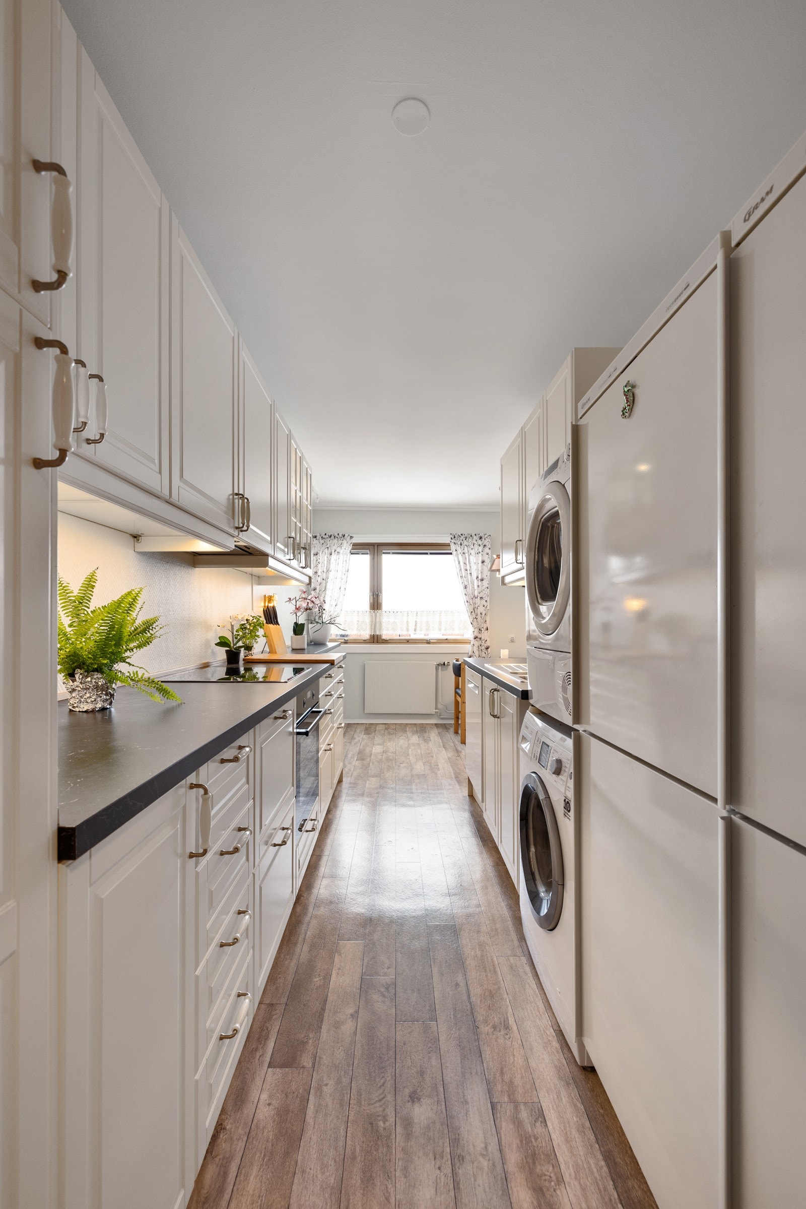 Rommet har integrert platetopp og komfyr, frittstående oppvaskmaskin, kjøl/frys, samt opplegg for vaskemaskin Galleribilde