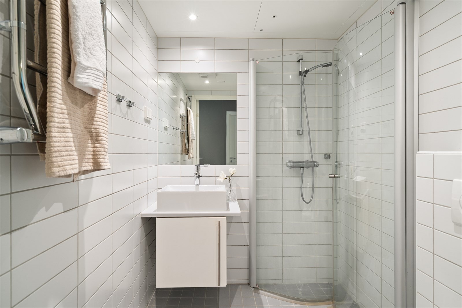 Bad 2 er innredet i samme moderne stil som hovedbadet, med fliser på gulv og vegger, samt lakkerte himlingsplater med innfelte downlights. Galleribilde