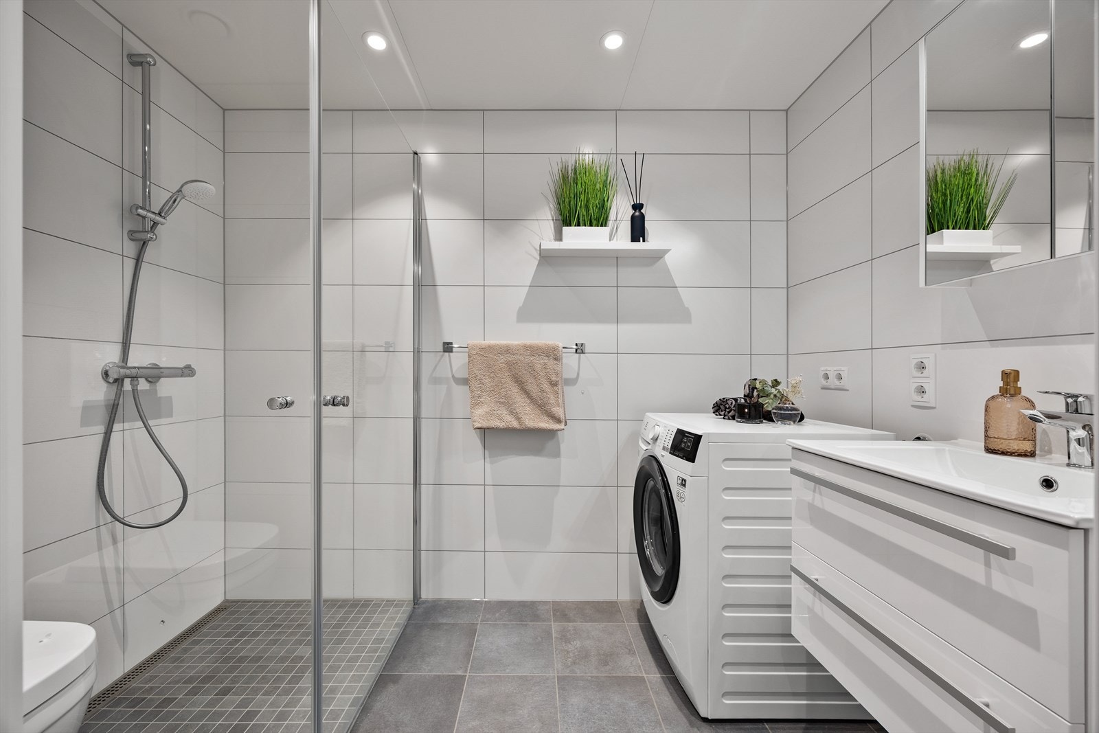 Moderne og pent flislagt bad med vannbåren gulvvarme og downlights i himlingen. Galleribilde