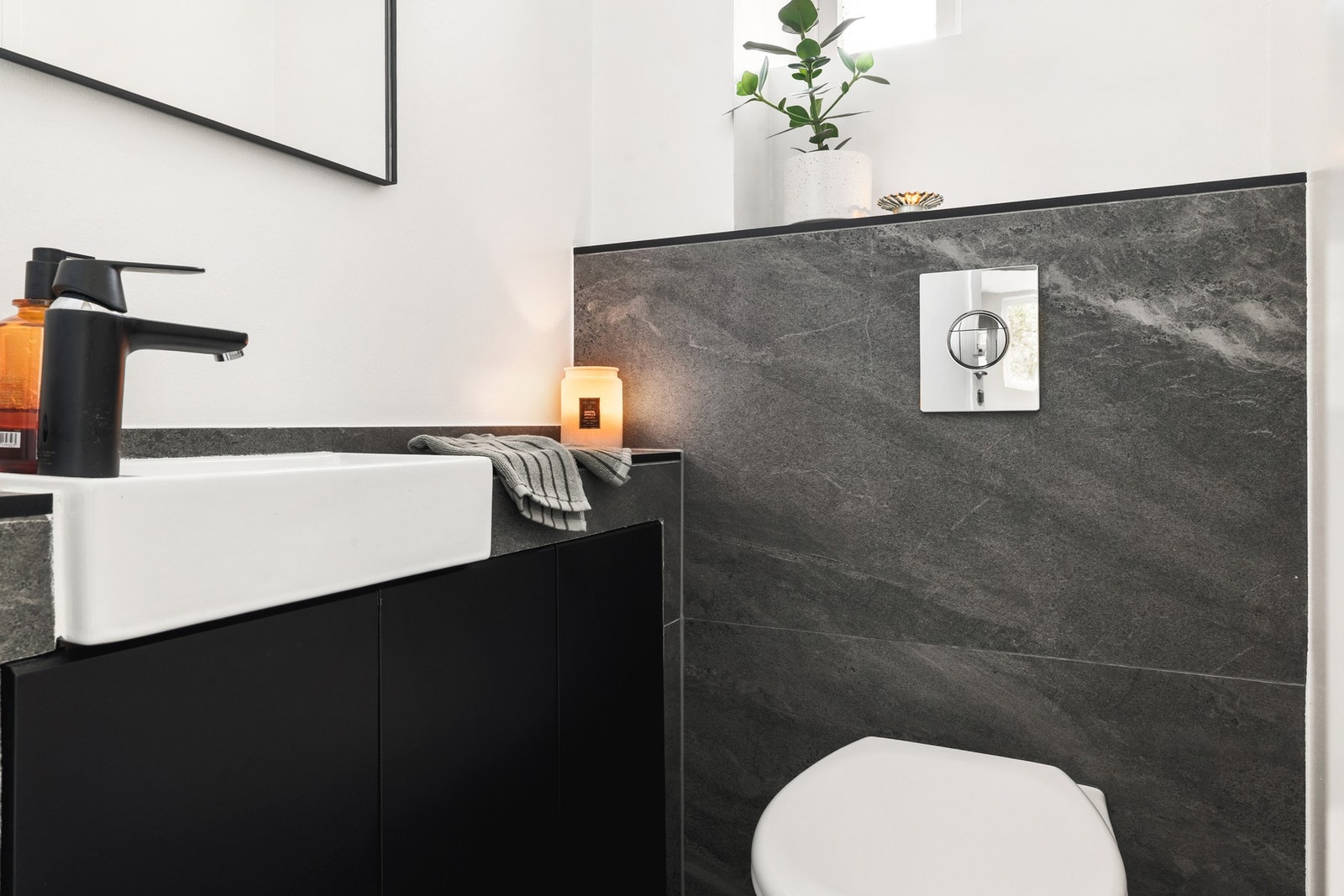 Toalettrommet måles til 1,2 kvm. og er fliselagt på gulv og delvis på vegg. Det er innredet med vegghengt toalett og servant med med skapinnredning og speil. Galleribilde