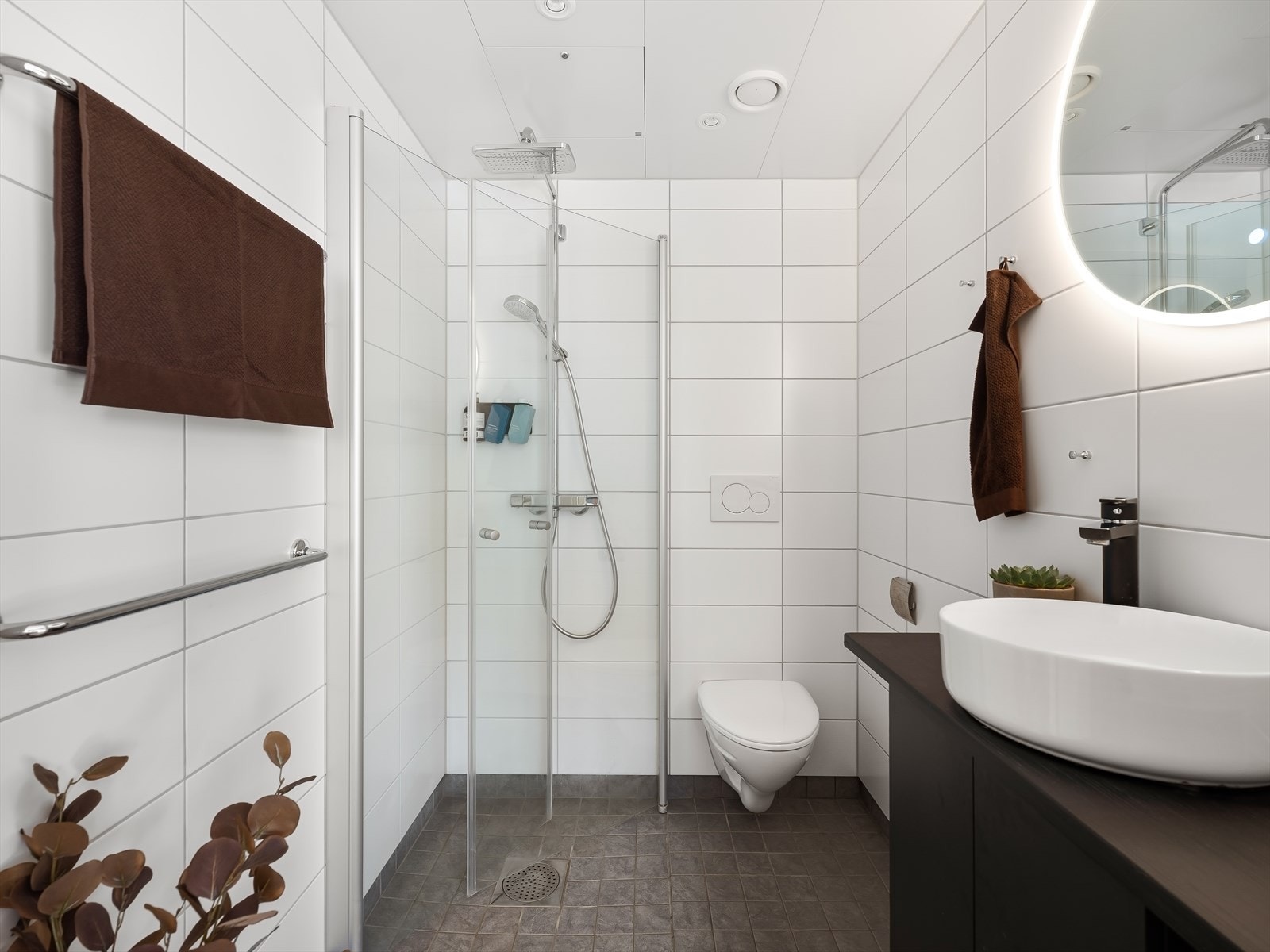 Flislagt bad med varmekabler, baderommsivredningen består av benkeskap med glatte fronter. Galleribilde