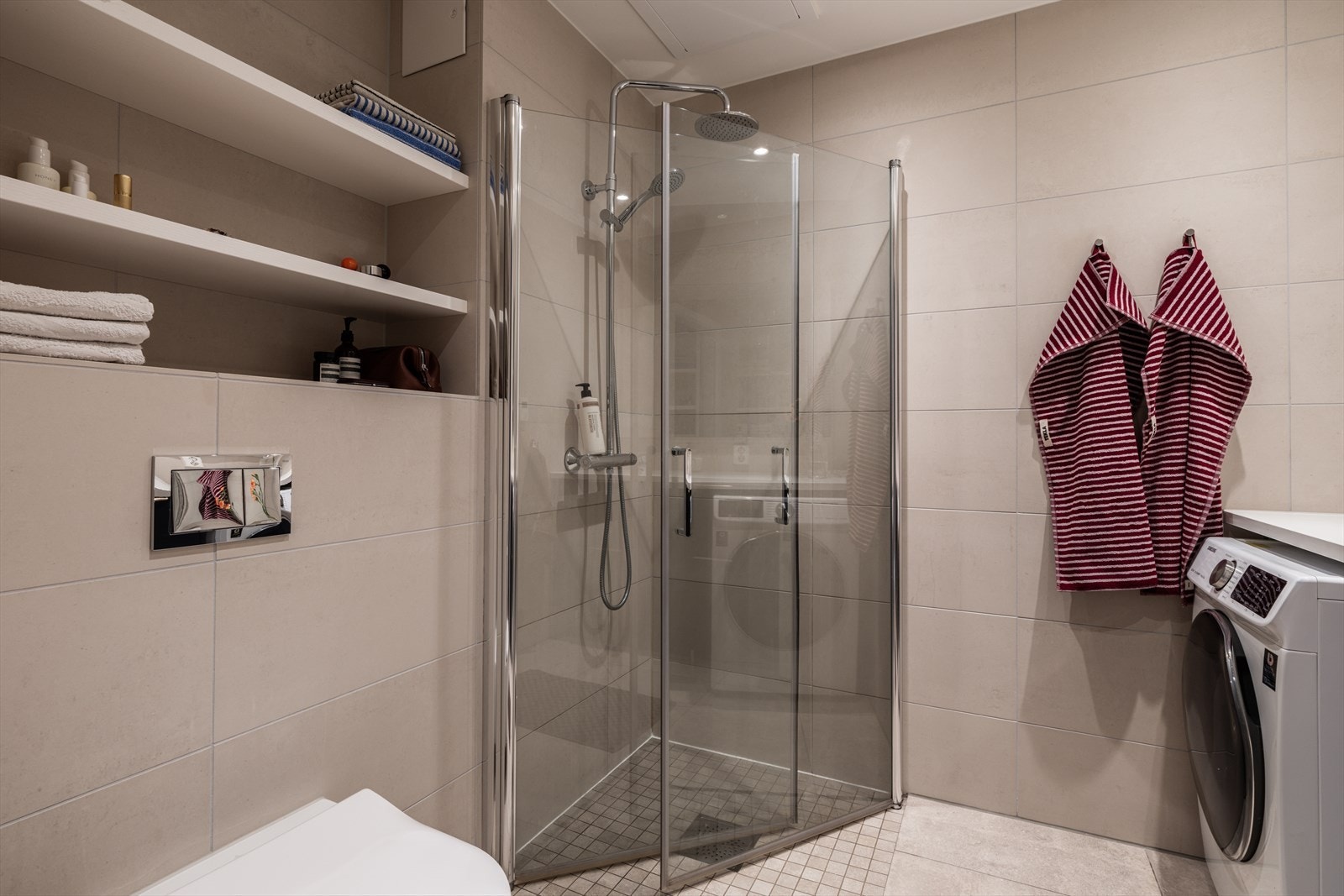 Innredningen består av vegghengt toalett, dusjhjørne, servant og opplegg for vaskemaskin. Galleribilde