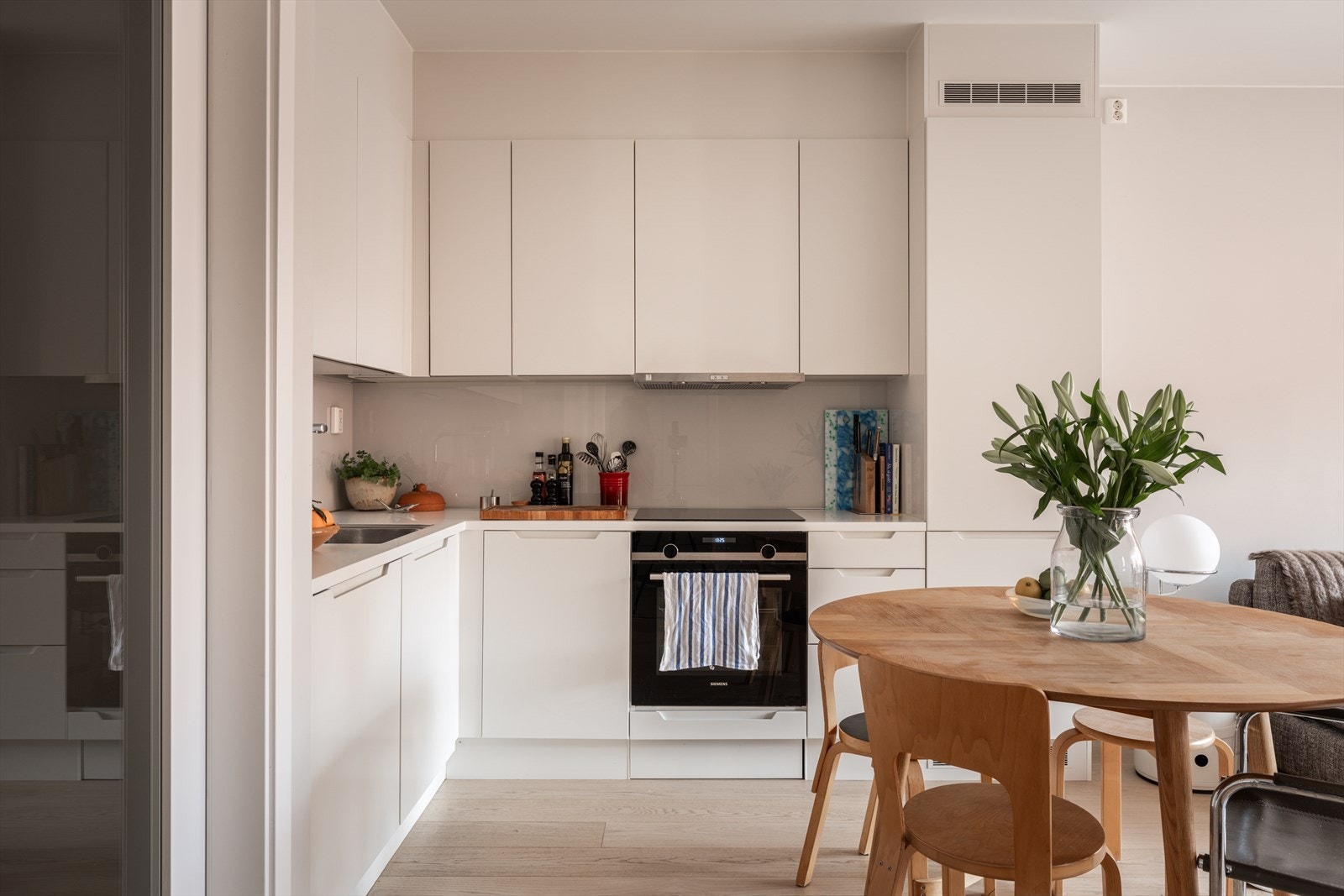 Kjøkken innredet med benkeplate i laminat og glassplate mellom over og underskap. Galleribilde