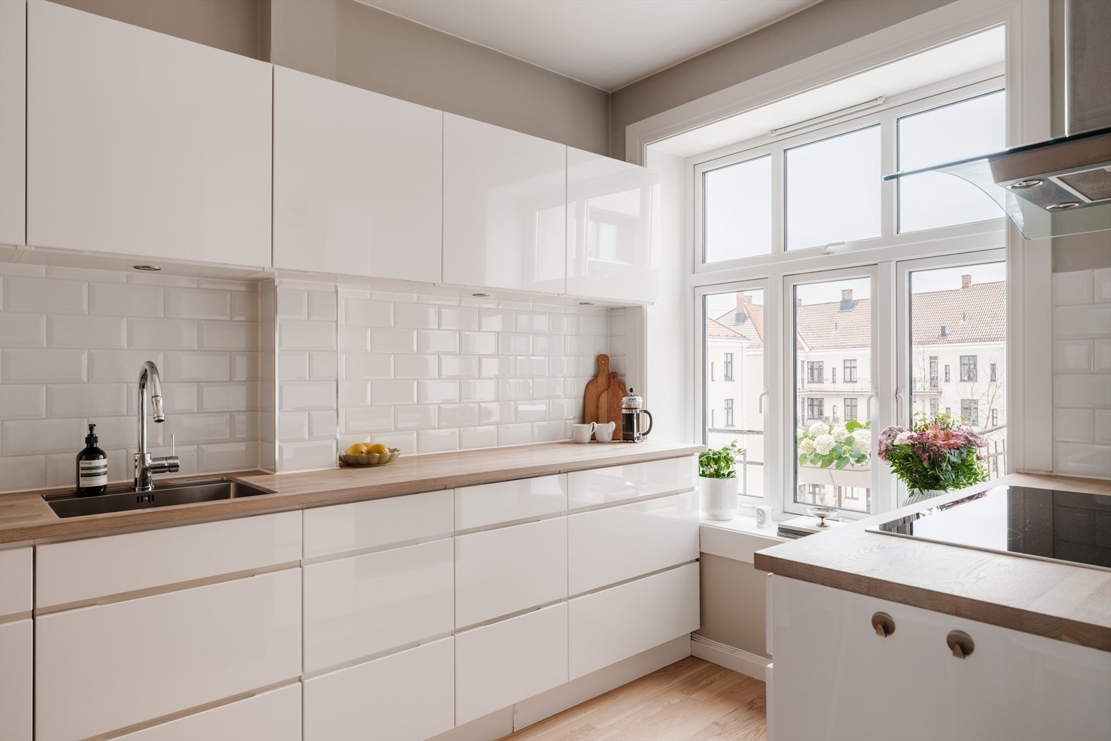 Innredningen består av hvite, glatte fronter, fliser over benken og heltre benkeplate med nedfelt oppvaskkum Galleribilde