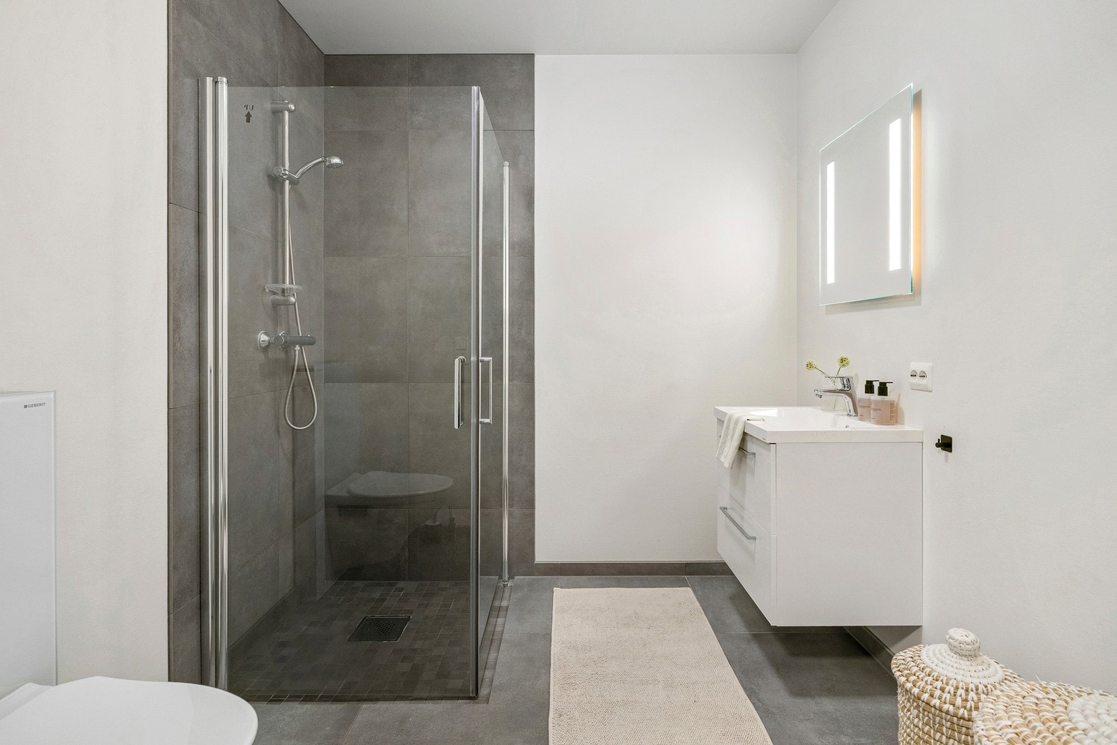 Badet i 1. etasje fremstår delikat og moderne, med flislagte gulv og vegger i tidløse farger. Galleribilde