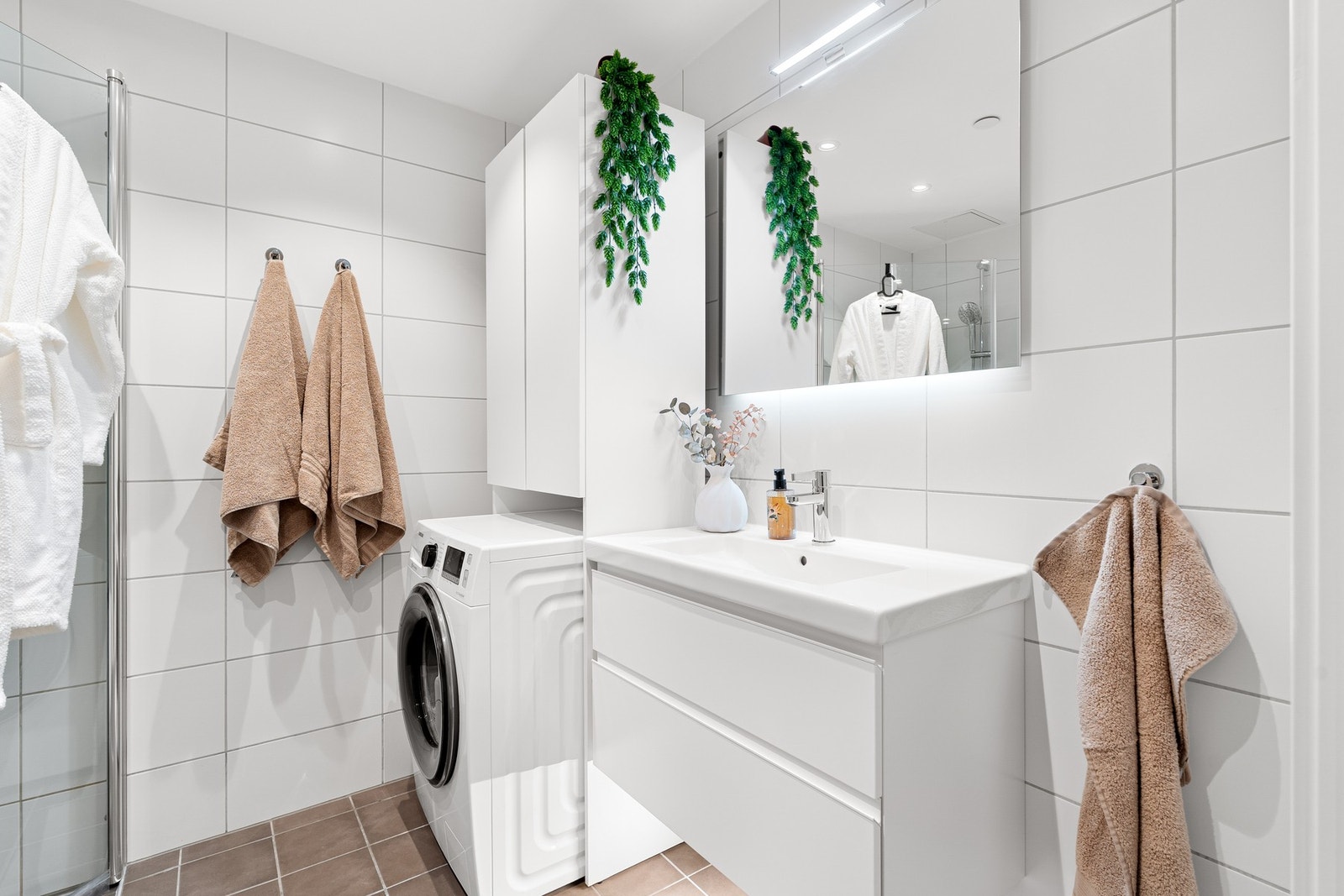 Badet har innfellbare dusjdører og opplegg for vaskemaskin. Galleribilde