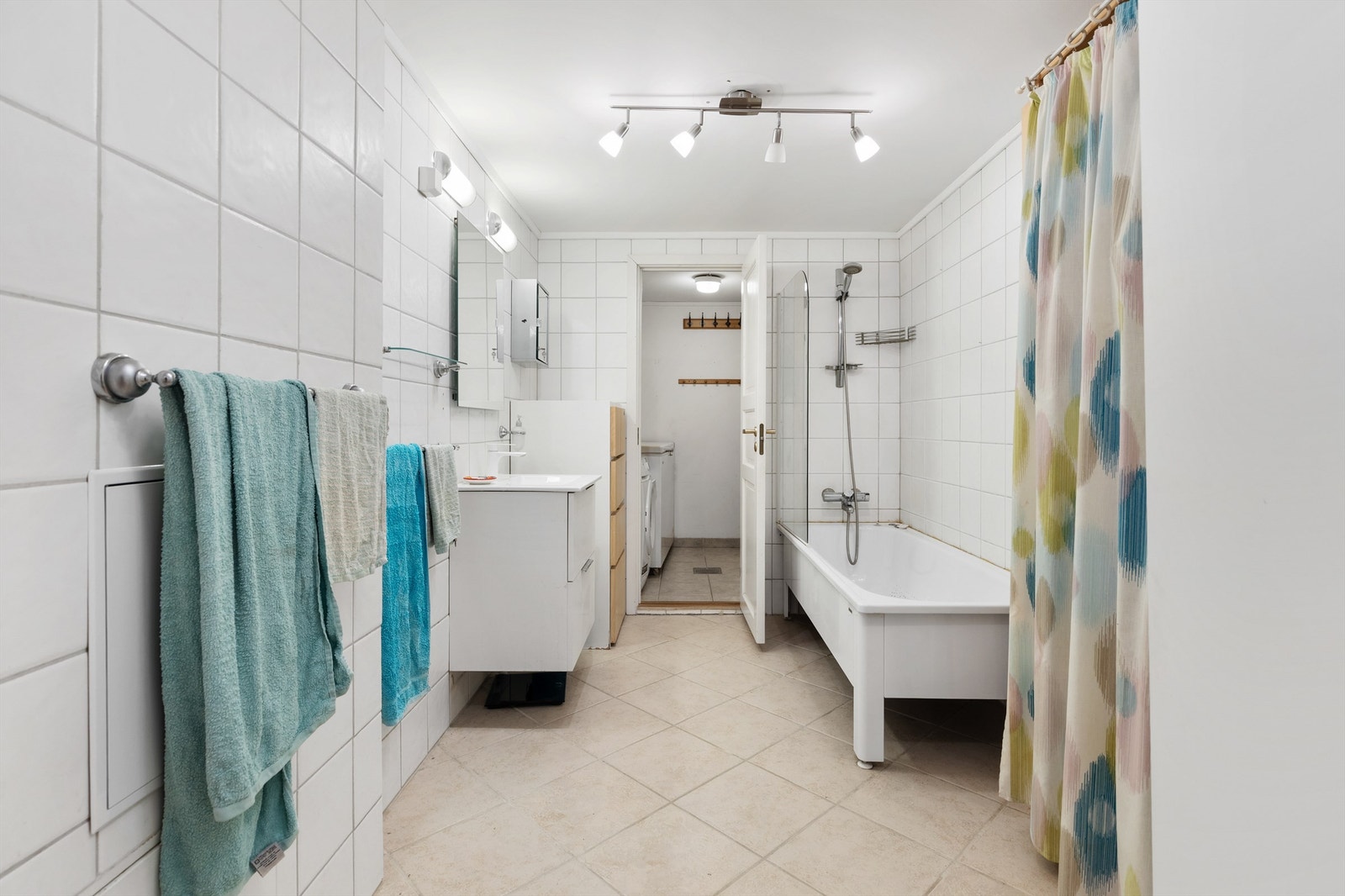 Badet har flislagte vegger og gulv Galleribilde