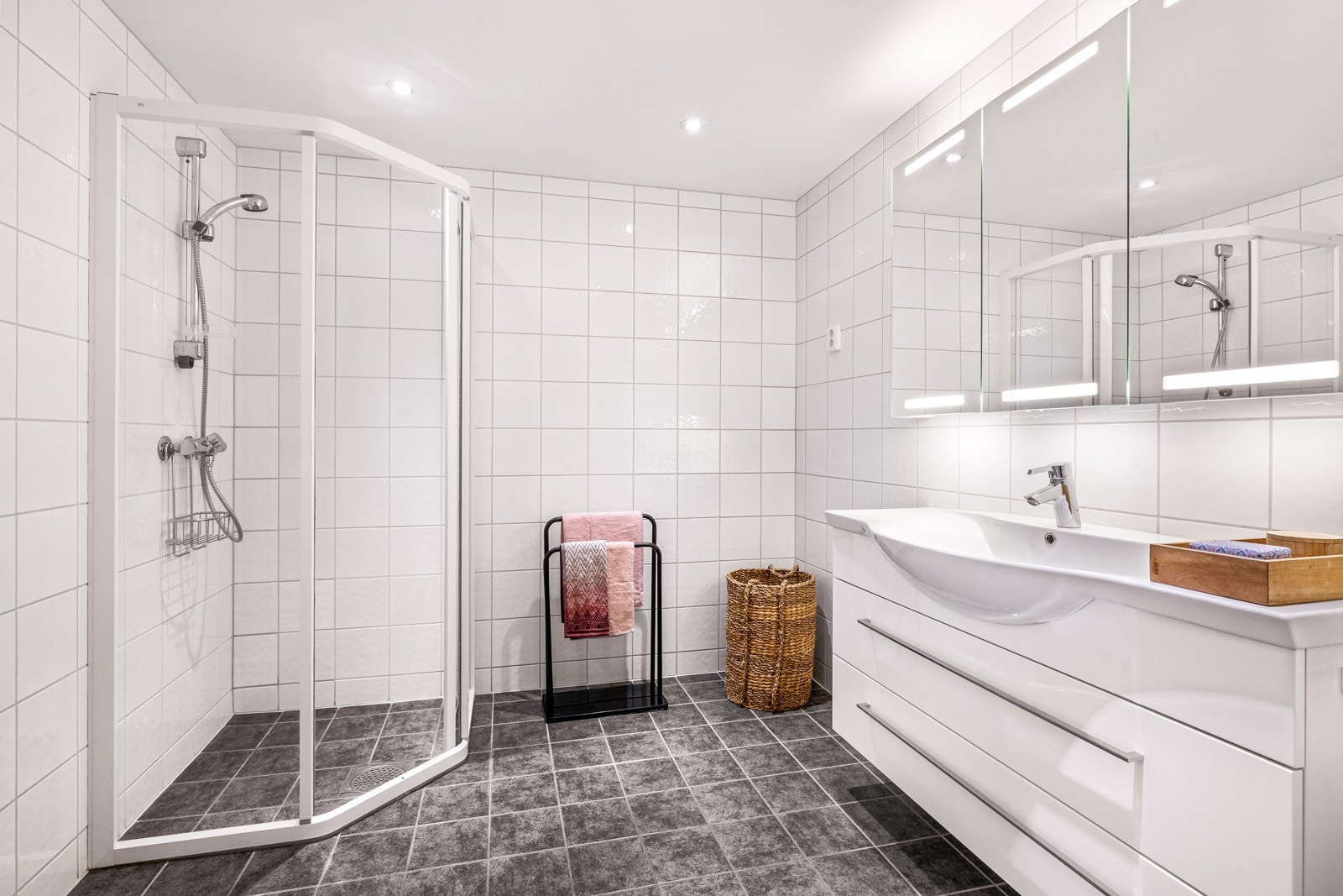 Stilsikker innredning, veggfestet toalett og dusjhjørne. Downlightsbelysning i tak. Galleribilde