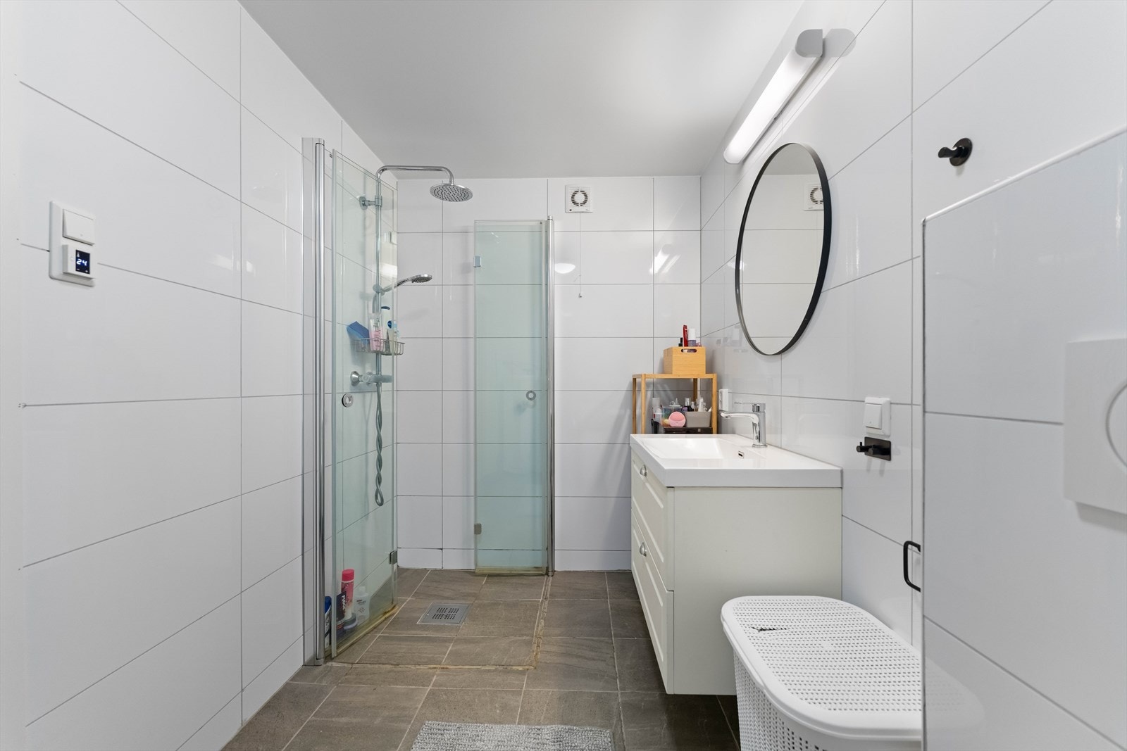 Badet er utstyrt med servantskap med nedfelt servant, dusjhjørne med glassdører, opplegg for vaskemaskin, varmtvannsbereder og vegghengt toalett. Galleribilde