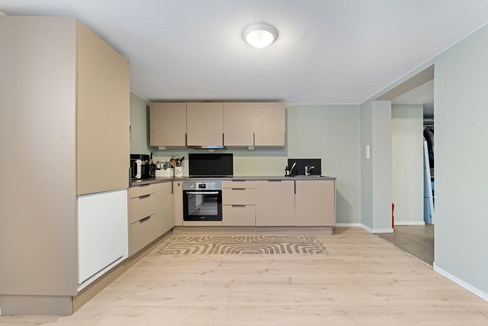 Kjøkkenet har slette fronter, nedfelt oppvaskkum, 1-greps blandebatteri og integrerte hvitevarer. Galleribilde