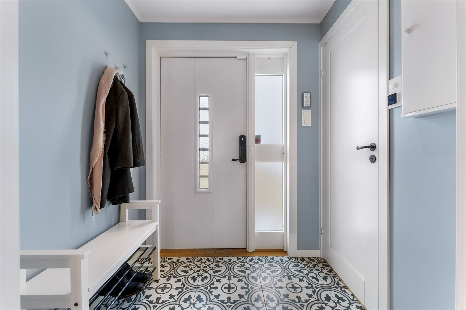 Boligen ønsker deg velkommen med en praktisk og stilfull entré belagt med historiske marokkanske fliser - et populært og karakteristisk valg som gir rommet særpreg. Galleribilde