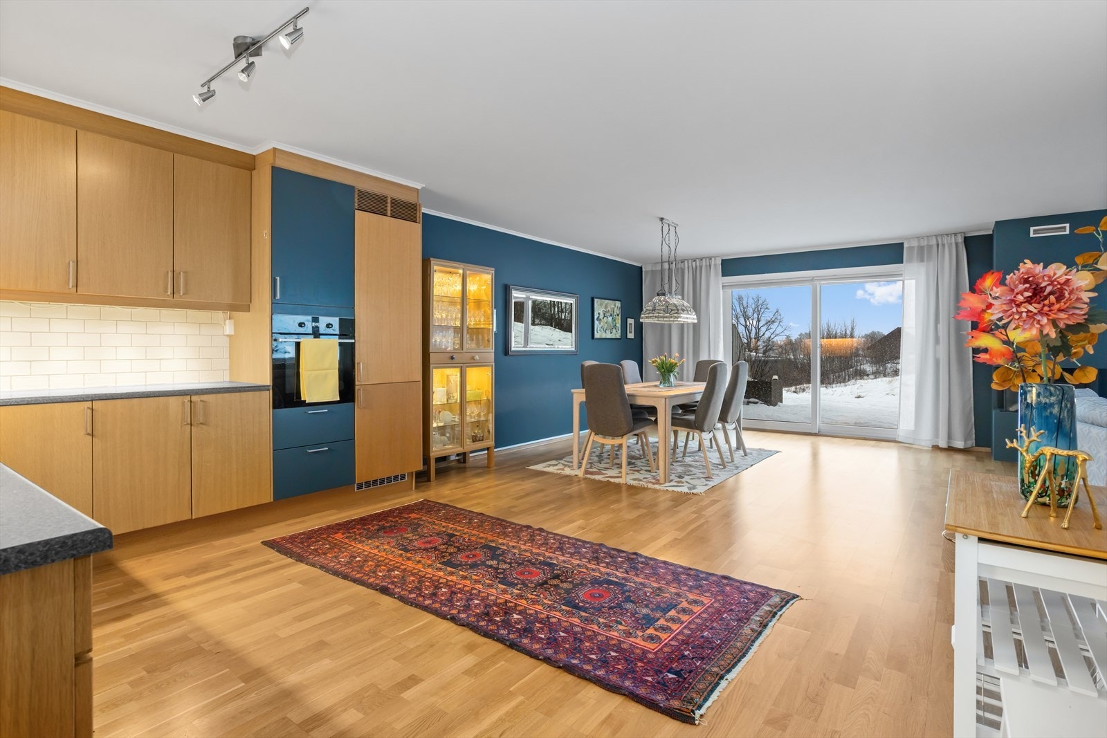 Meget romslig, lys og delikat STUE-/SPISESTUE med peis og vinduer mot både syd og vest. Mot syd er det dobbel skyvedør som leder ut til leilighetens to sammenhengende terrasser på hele 62 m². Galleribilde