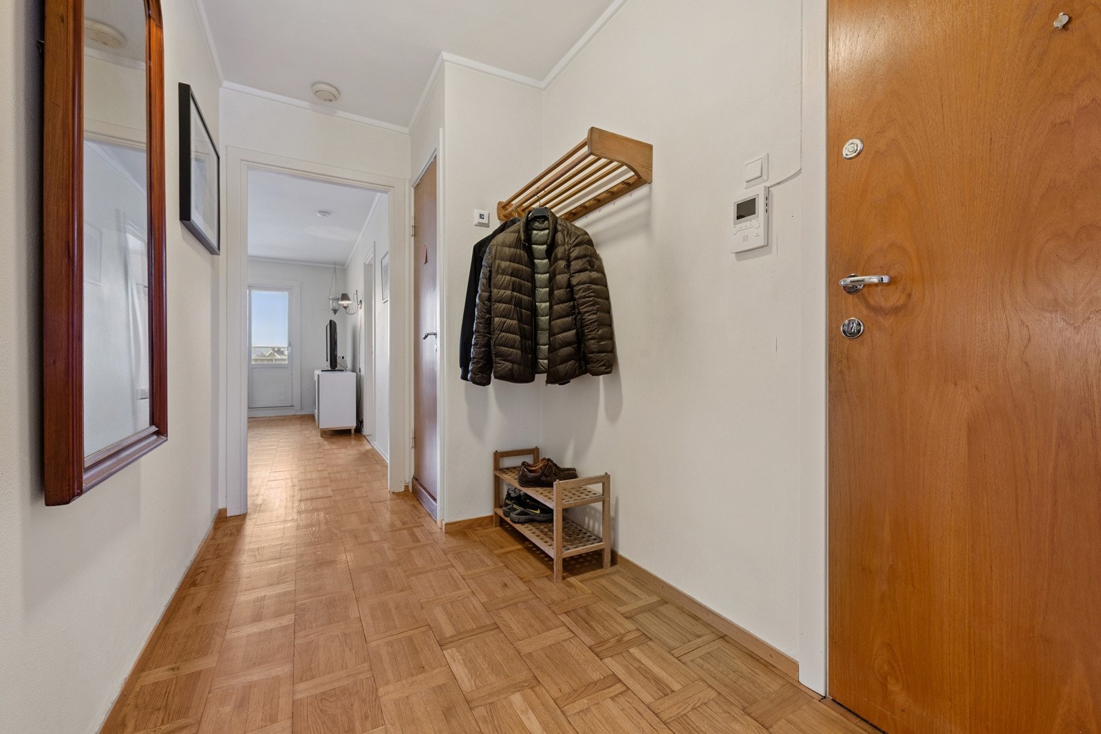 Leiligheten har en romslig entré med plass til oppbevaring av klær og sko. Galleribilde