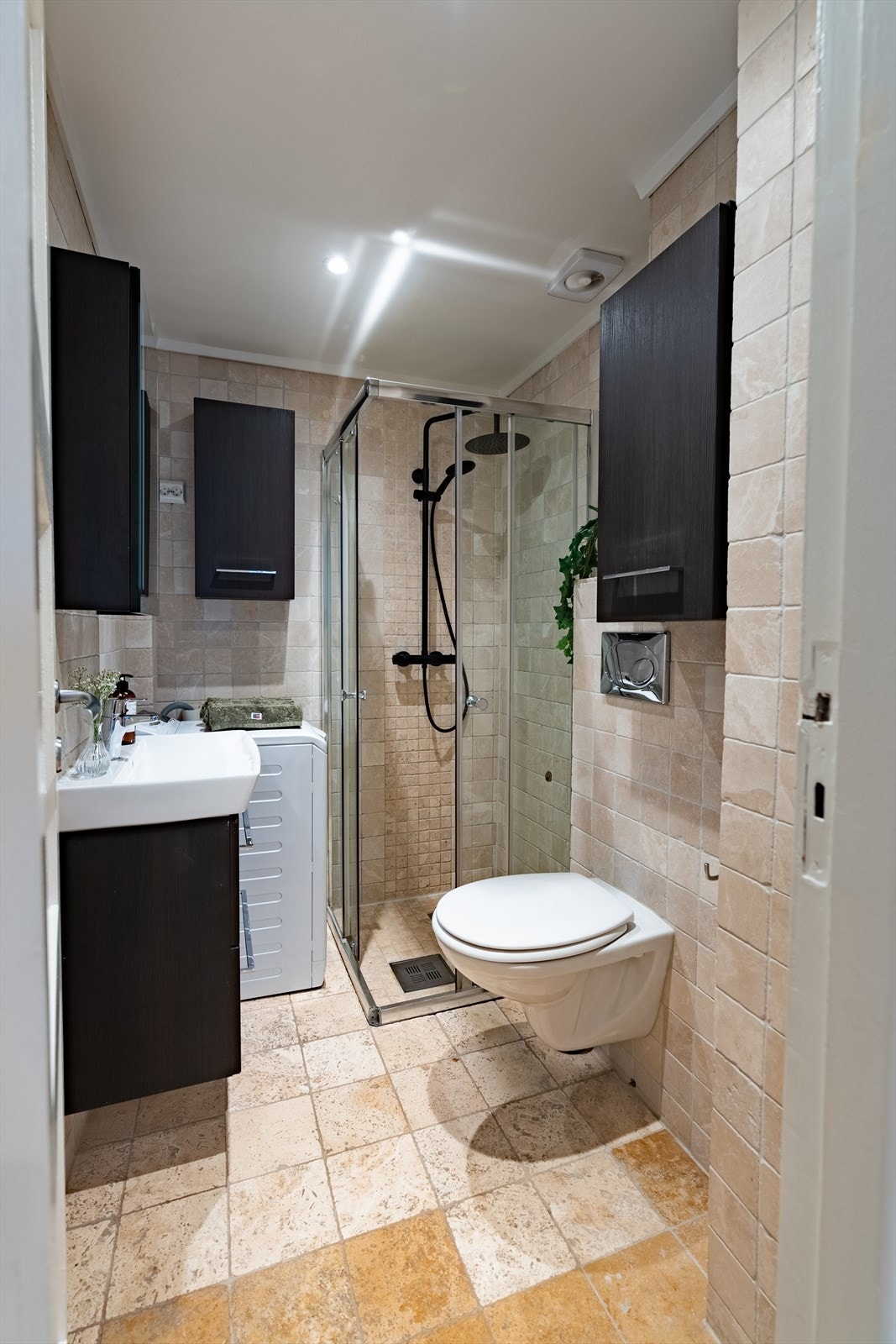 Baderommet er innredet med vegghengt toalett, servantskap, speil og dusjhjørne. Det er opplegg for vaskemaskin. Galleribilde