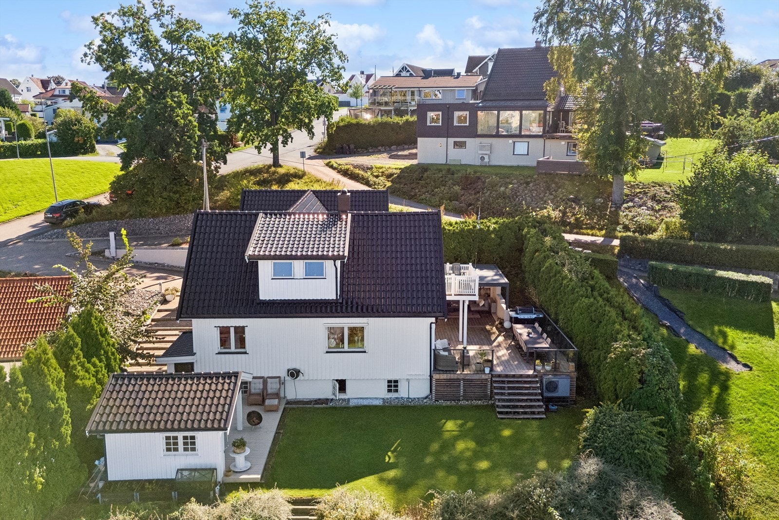 Tomten er pent opparbeidet med rullestein, gressplen, diverse beplantning og prydbusker. Galleribilde