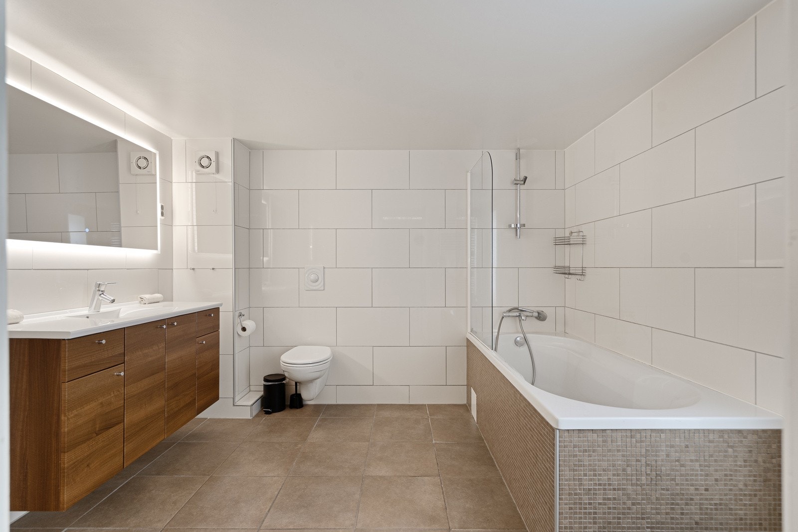 Bad og vaskerom er kombinert og praktisk innredet, med gode løsninger for klesvask og oppbevaring. Galleribilde