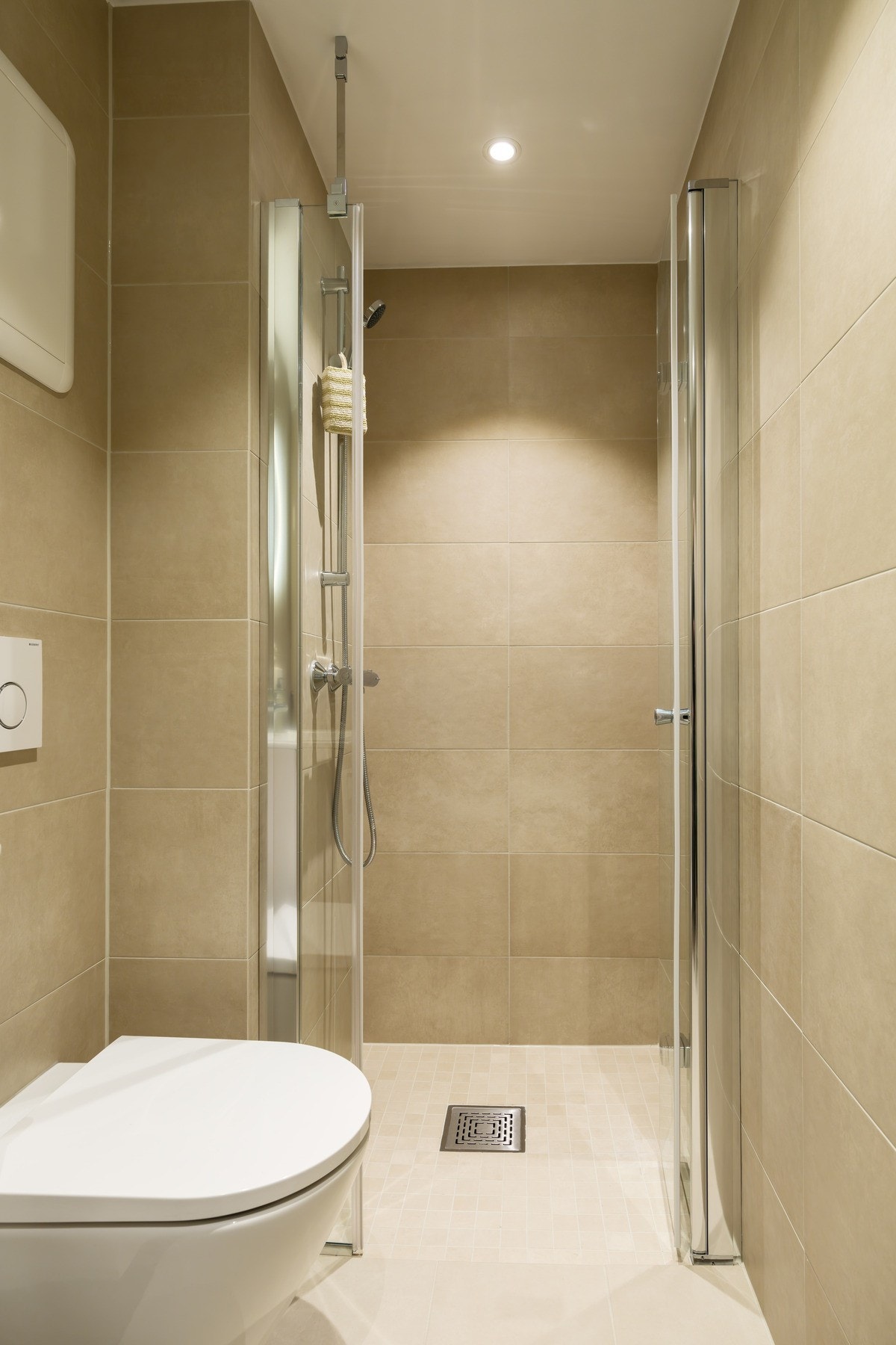 Bad med beige fliser på gulv og vegg Galleribilde