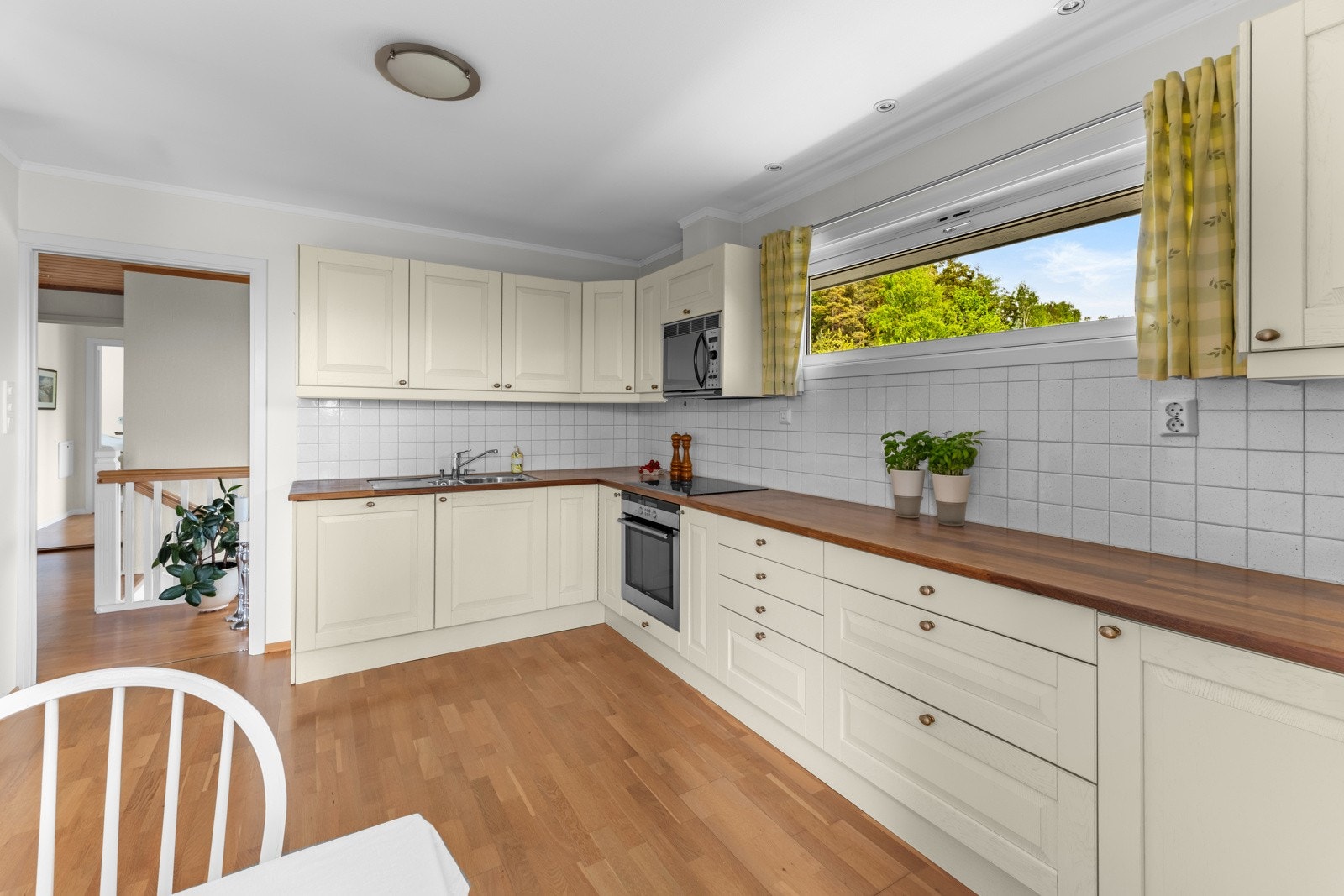 Kjøkkenet er av god størrelse med rikelig skap- og benkeplass for oppbevaring og matlaging Galleribilde