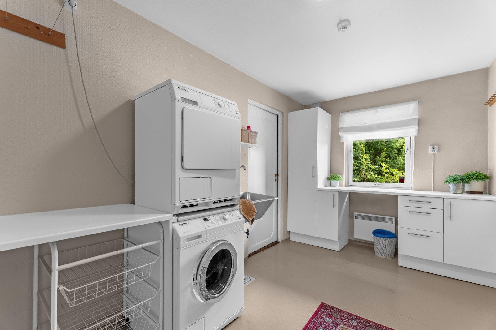 Funksjonelt vaskerom med rikelig oppbevaringsplass - ideelt for både vask og organisering Galleribilde
