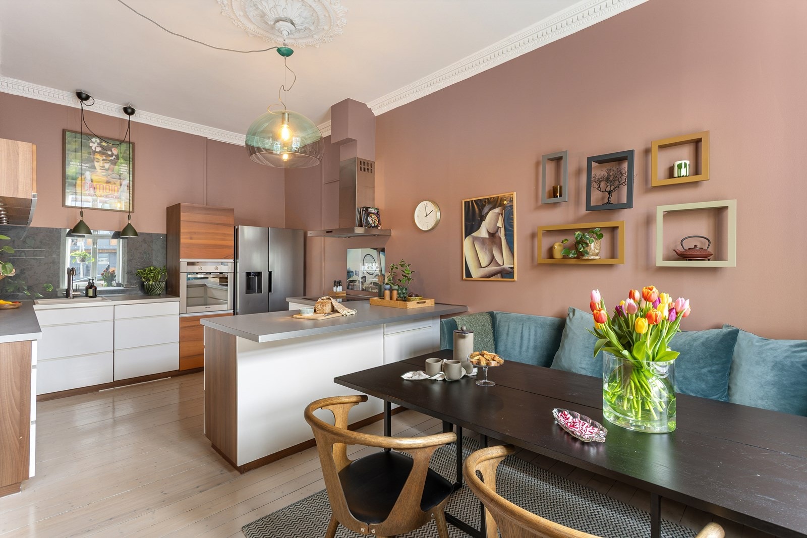 Kjøkkeninnredning med glatte fronter, laminat benkeplate med nedfelt vaskekum, samt belysning og plate over benkeplaten. Galleribilde