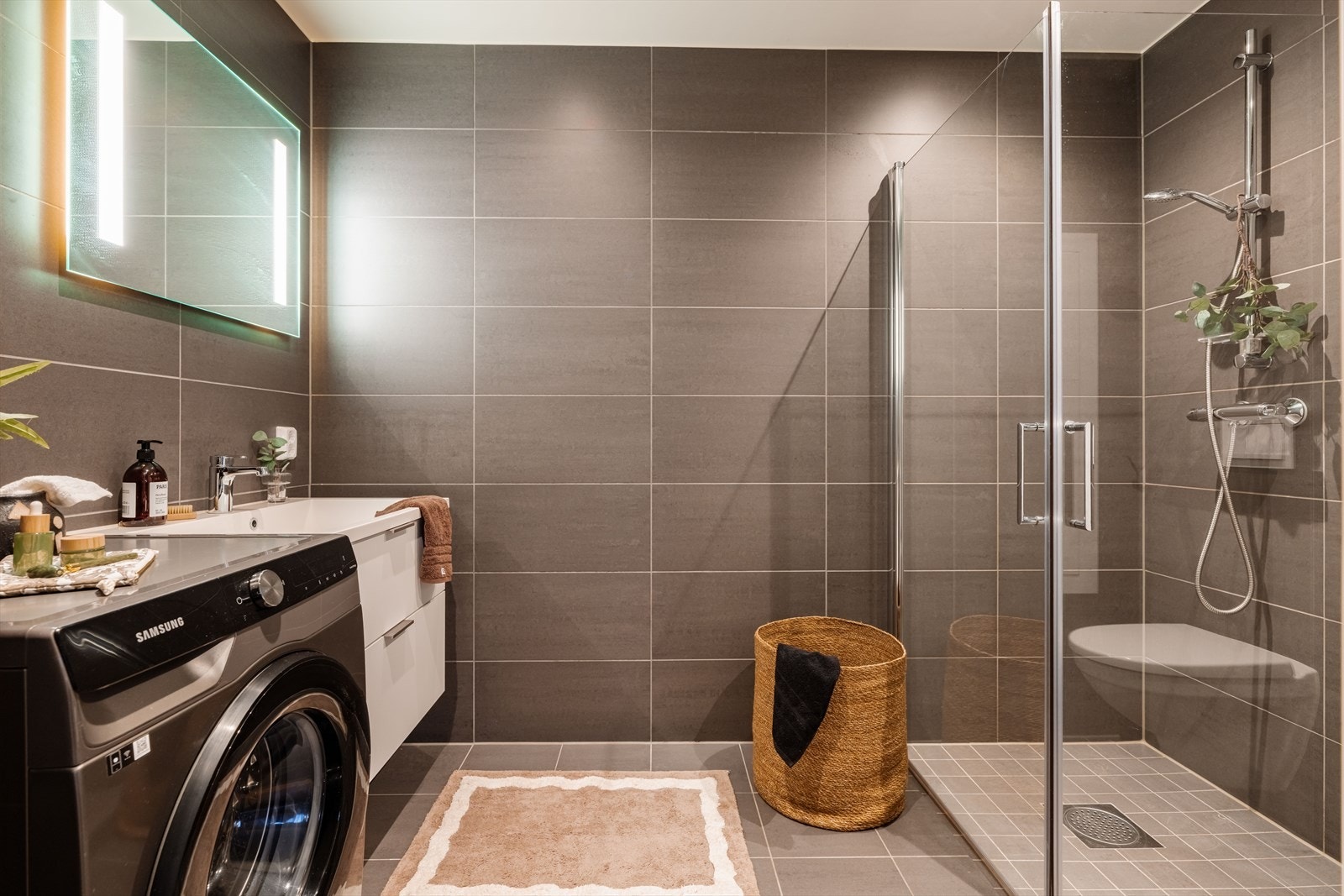 Moderne og helfliset bad med grå 30x60 fliser på vegg og 15x15 fliser på gulv. Galleribilde